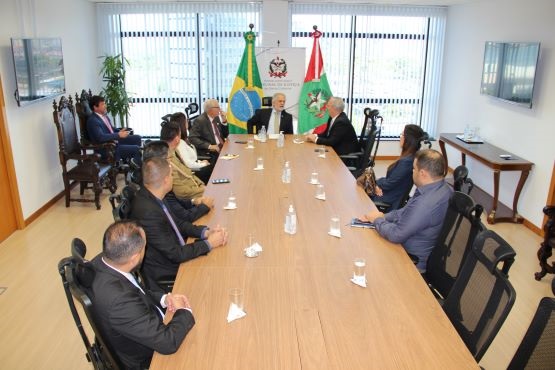 presidente do Tribunal de Justiça de Santa Catarina (TJSC), desembargador João Henrique Blasi sentado ao centro de uma mesa retangular com representantes tocantinenses
