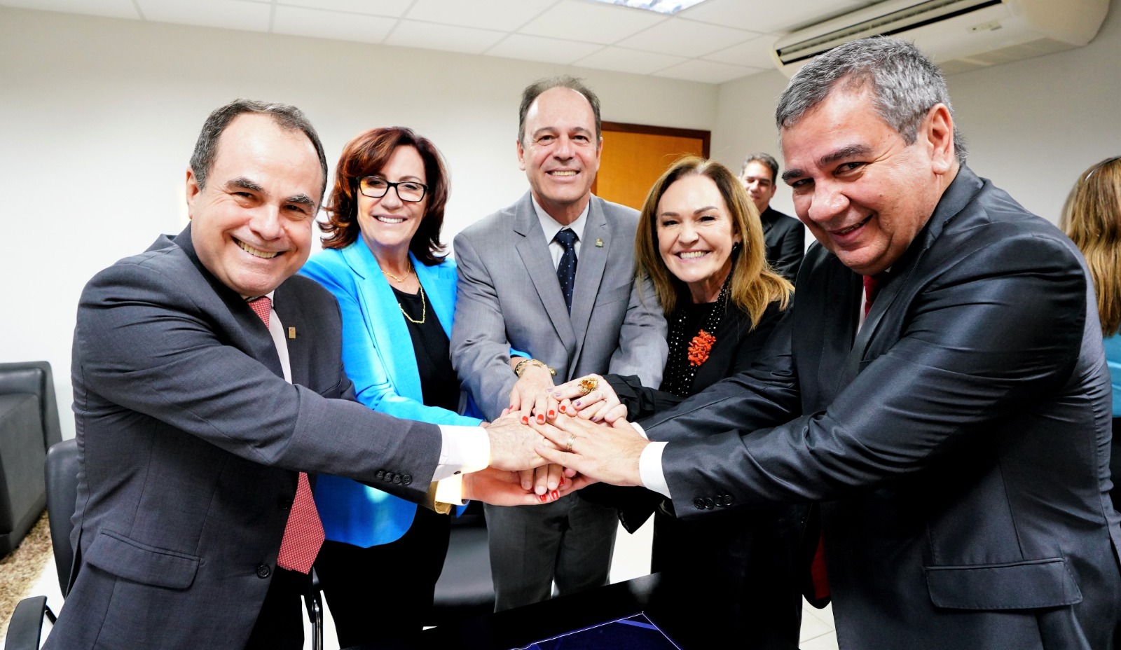 Representantes das instituições parceiras, inclusive a presidente desembargadora Etelvina Maria Sampaio Felipe,  na criação do mestrado juntos com as mãos das posando para foto
