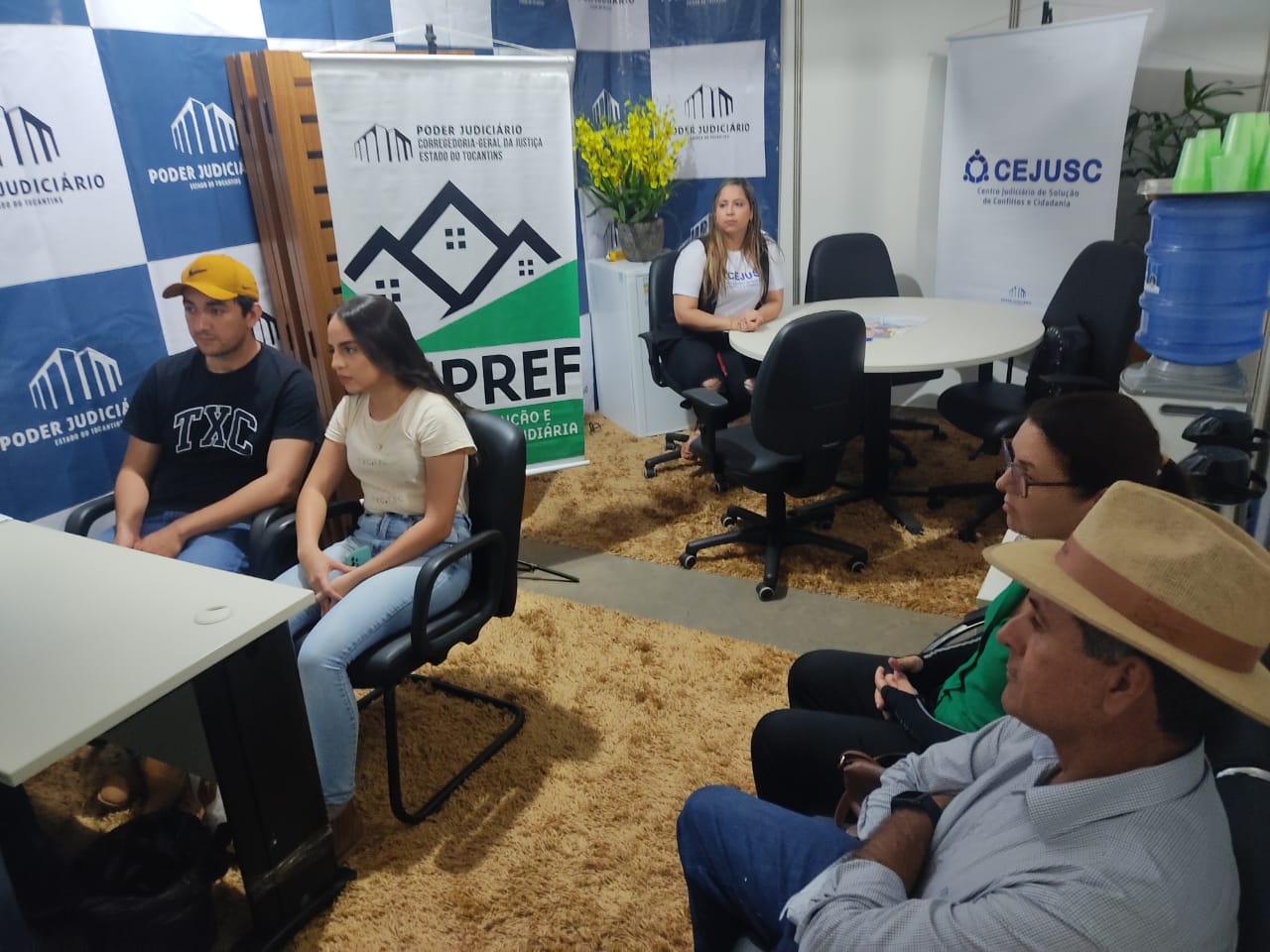 casal sentado sendo atendido no estande do nupref na agrotins