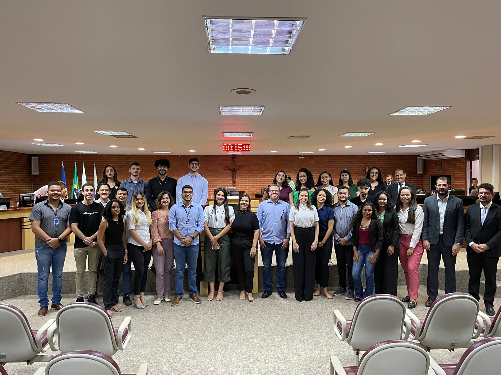 Imagem colorida que mostra várias pessoas que trabalham no Nacom posando para a foto no Tribunal do Pleno 
