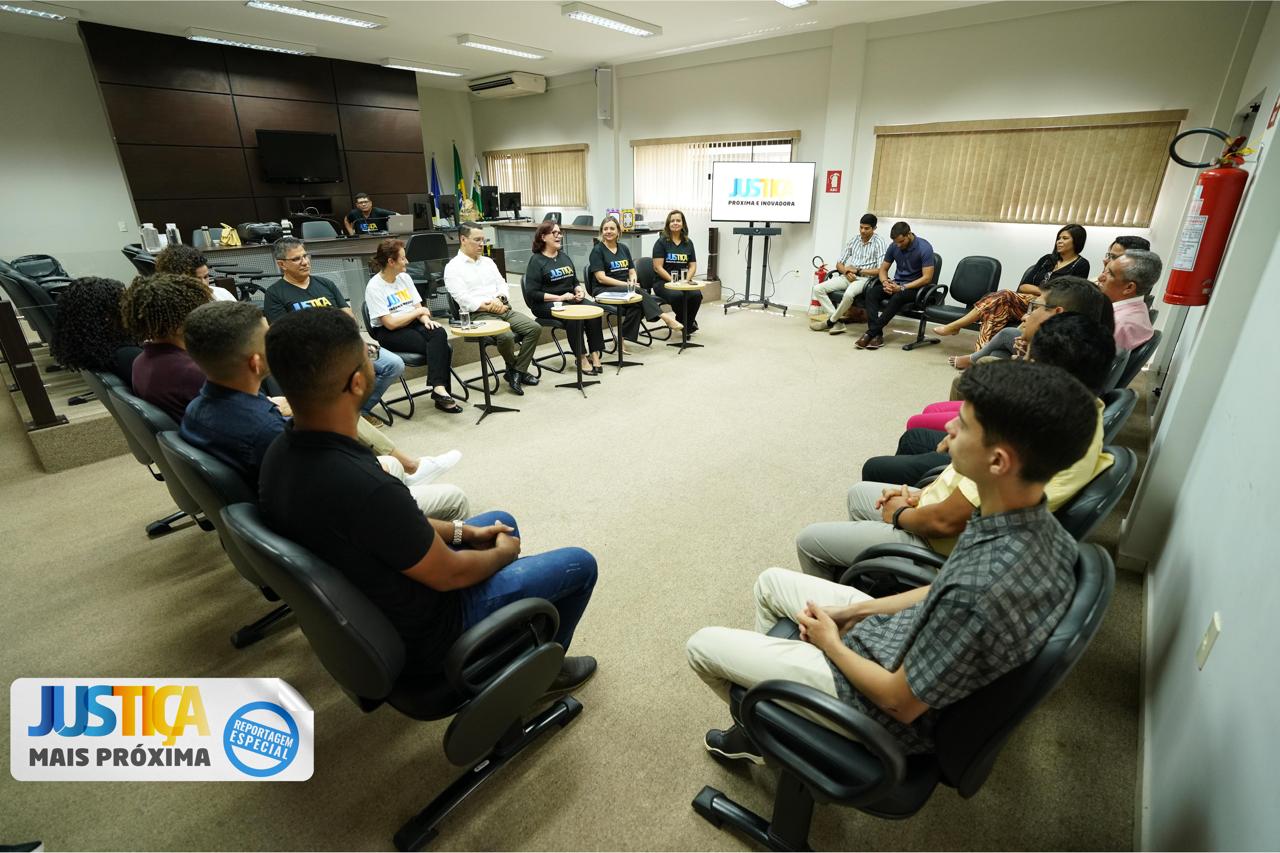 Grupo de pessoas reunidas promovendo interação e um logotipo visível sobre a justiça mais próxima e inovadora.