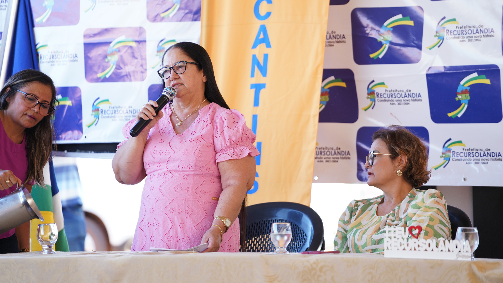 Tabeliã do Cartório de Registro de Imóveis fala segurando microfone