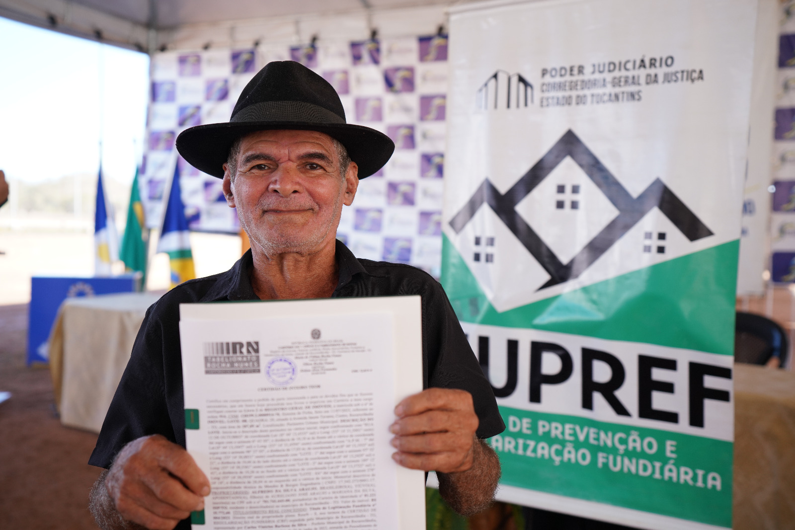Seo Alfredo posando para foto segurando titulo de propriedade