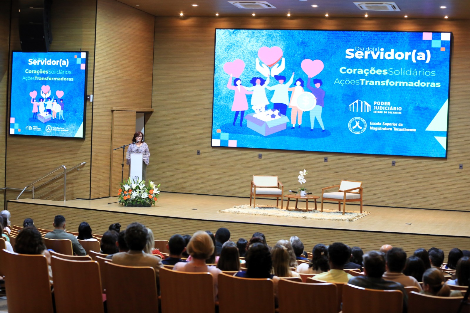 Desembargadora fala num pulpito para plateia atenta