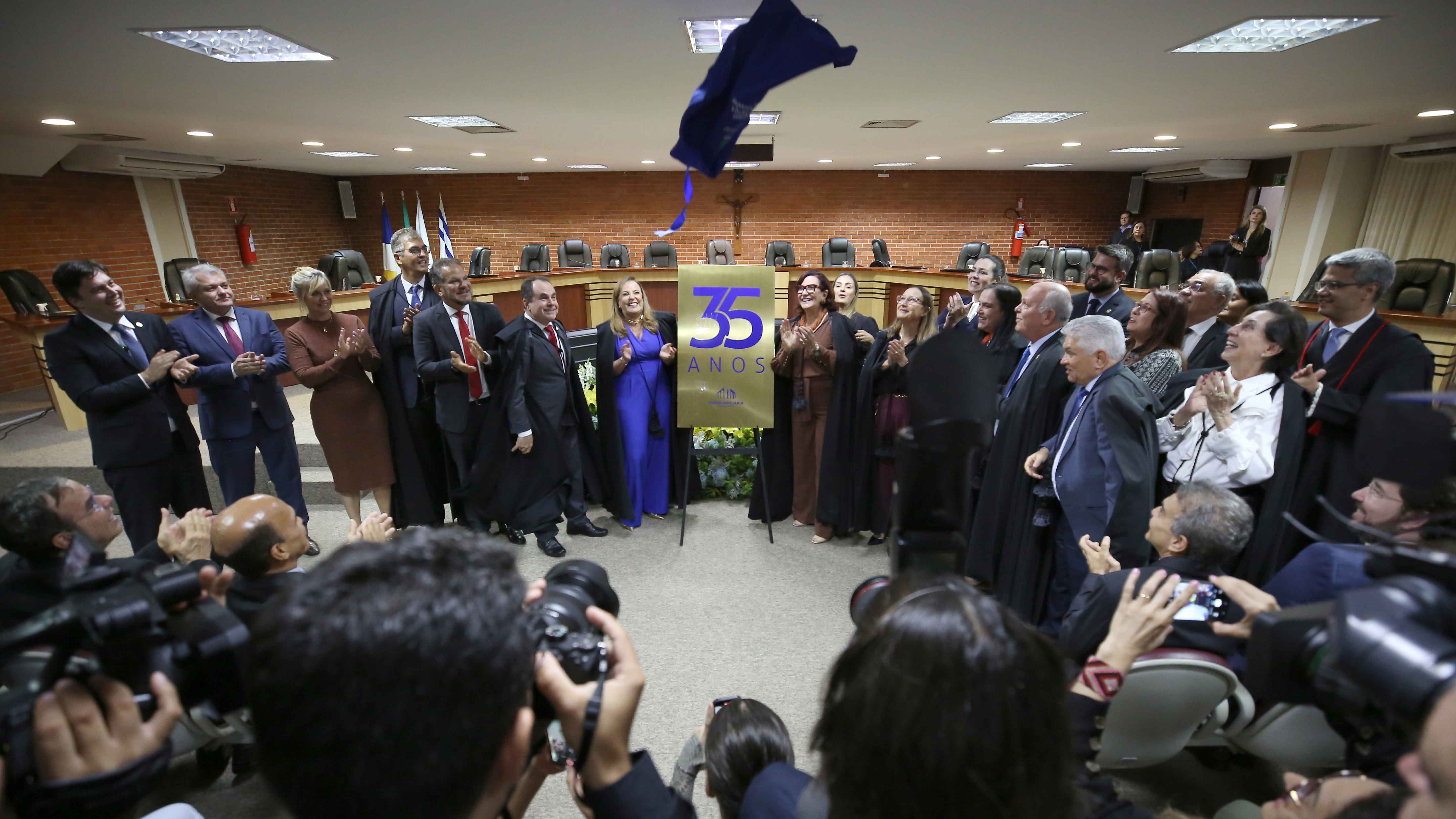 Foto no pleno do TJTO; pessoas em pé descerram placa de 35 anos do Tribunal