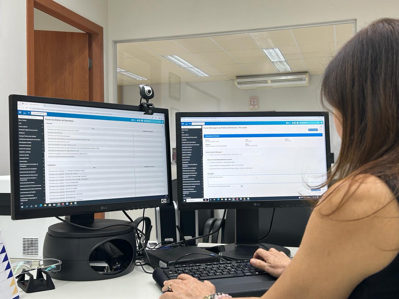imagem de uma jovem (detalhe) acessando a ferramenta; à sua frente dois monitores e um teclado de computador