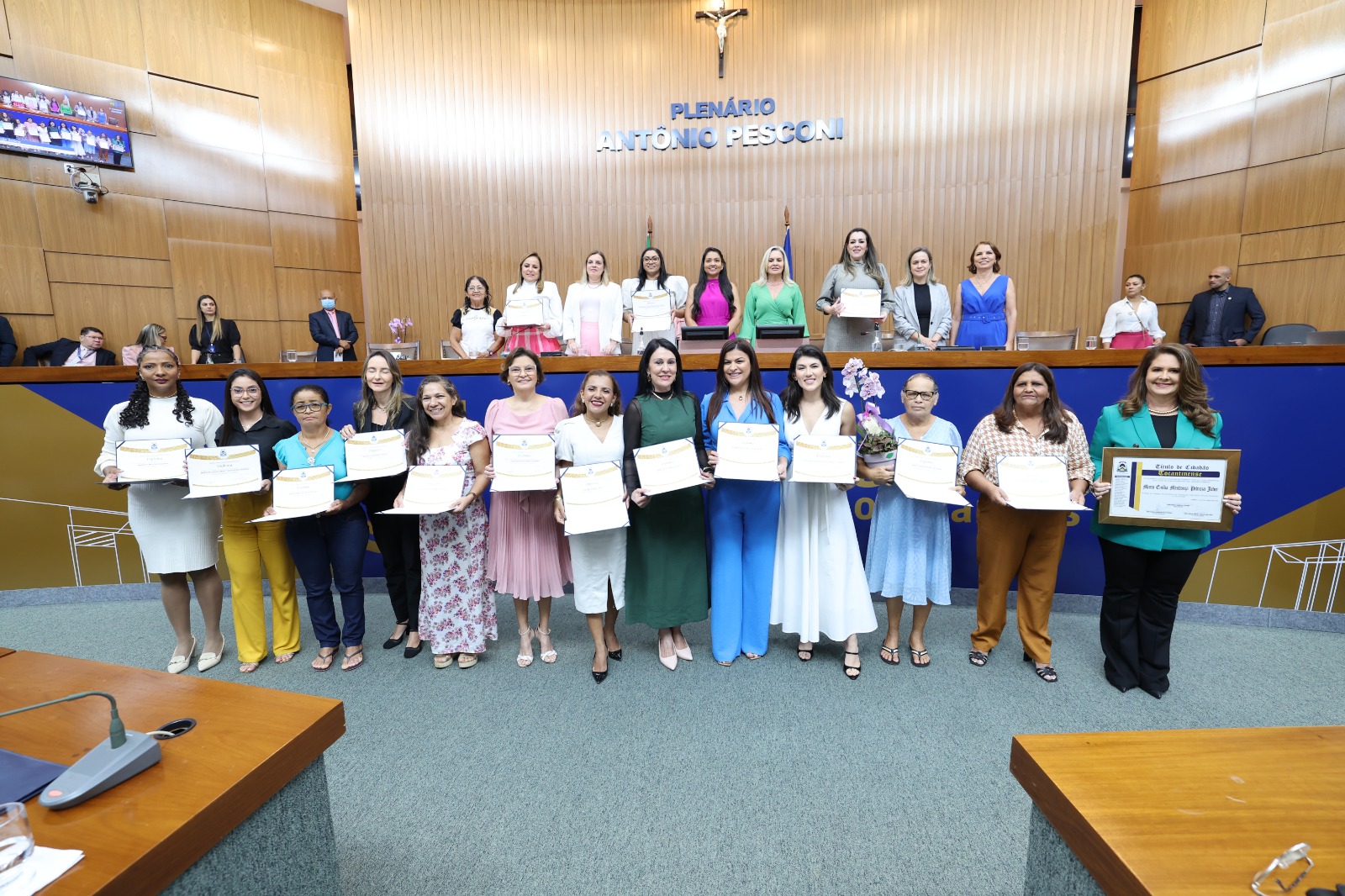 Imagem colorida que mostra mulheres segurando um diploma