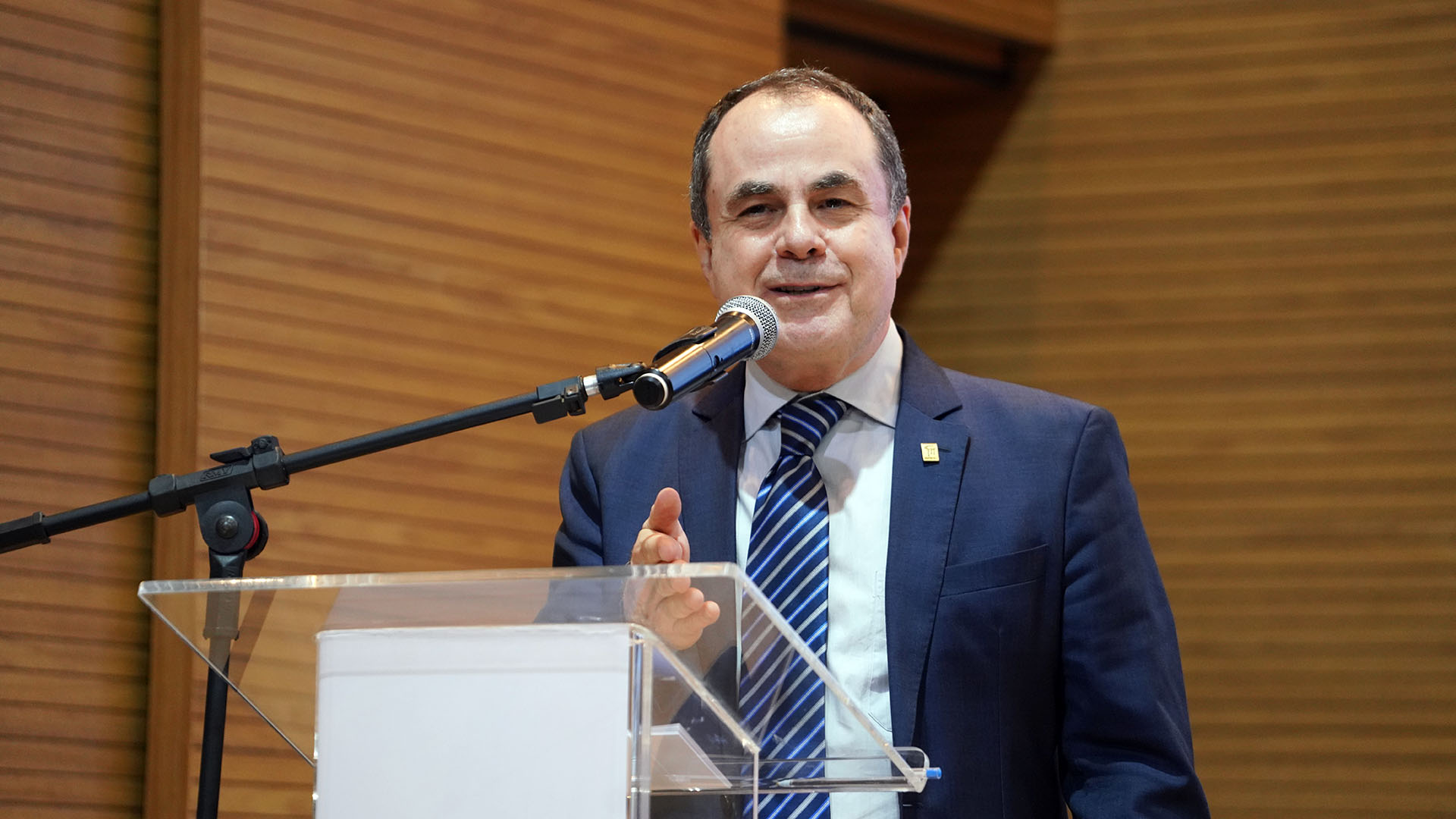 Imagem colorida de homem branco discursando. Ele usa terno e gravata