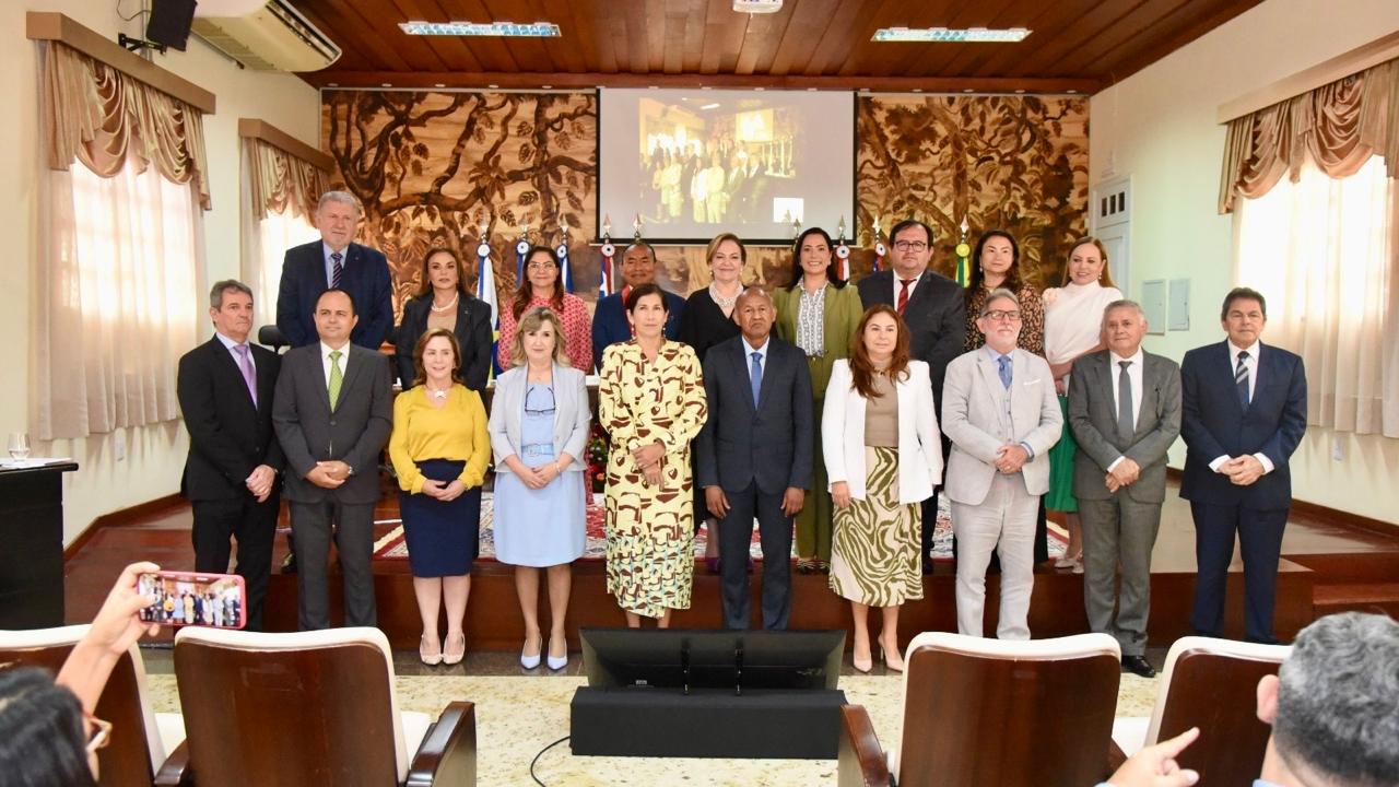 homens e mulheres autoridades estão perfilados posando para foto