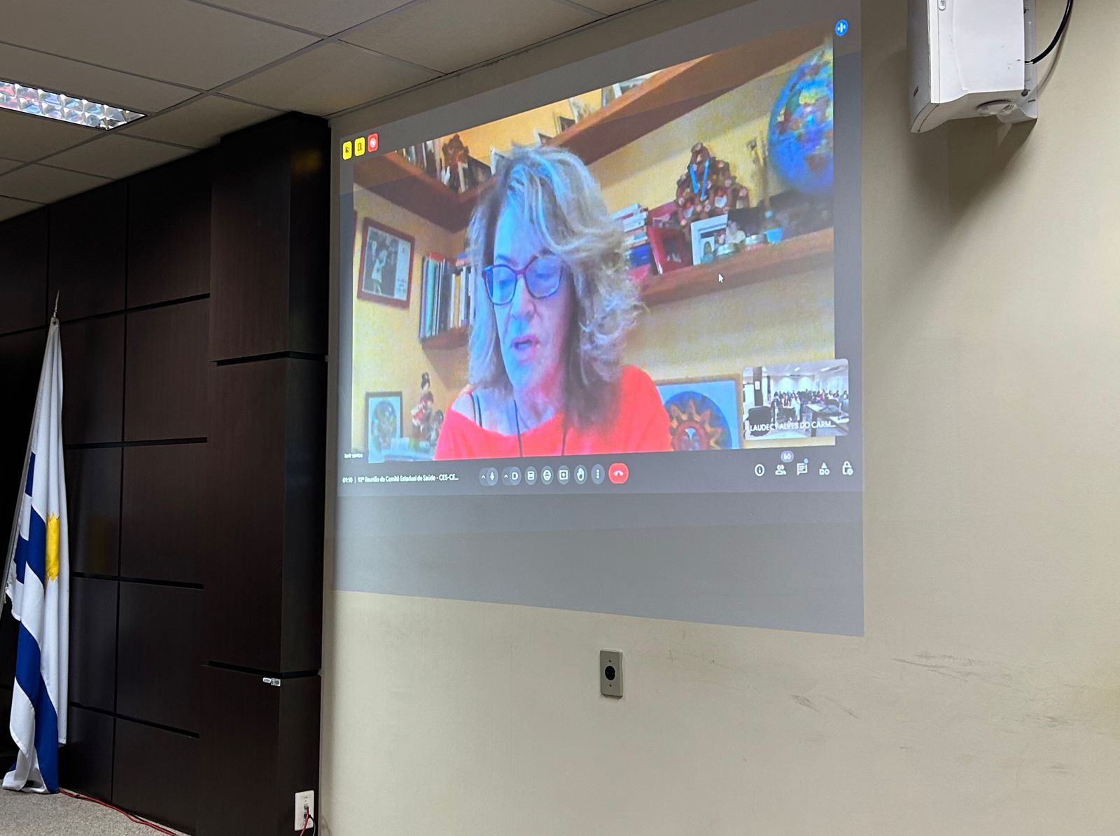 Fotografia colorida que mostra uma mulher projetada numa parede