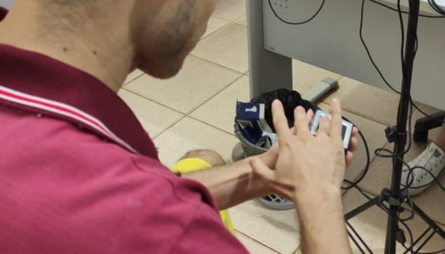 Imagem mostra a mão de um homem branco colocando o dedo em um aparelho de biometria