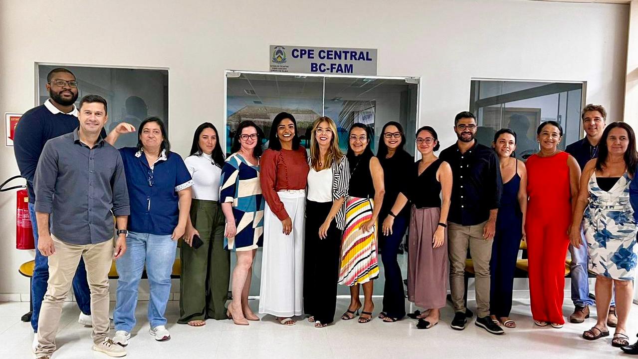 homens e mulheres posam para foto em frente ao bloco de competências da família