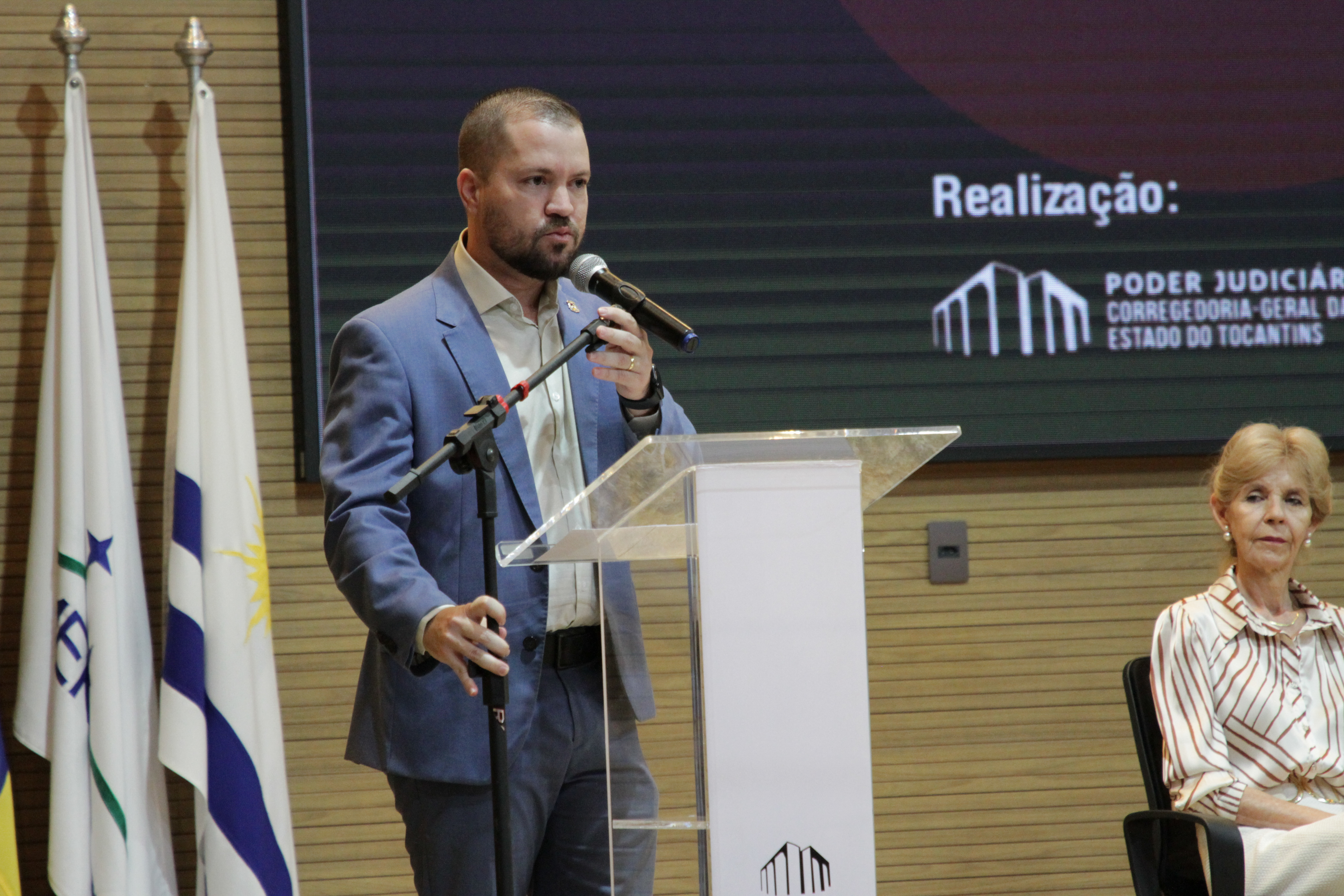 Fotografia colorida que mostra um homem branco de barba usando terno cinza