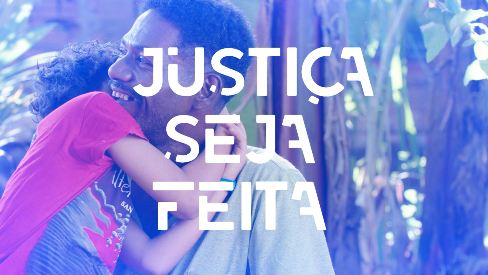 Foto desfocada de um homem negro abraçando uma criança; à frente a frase Justiça seja feita