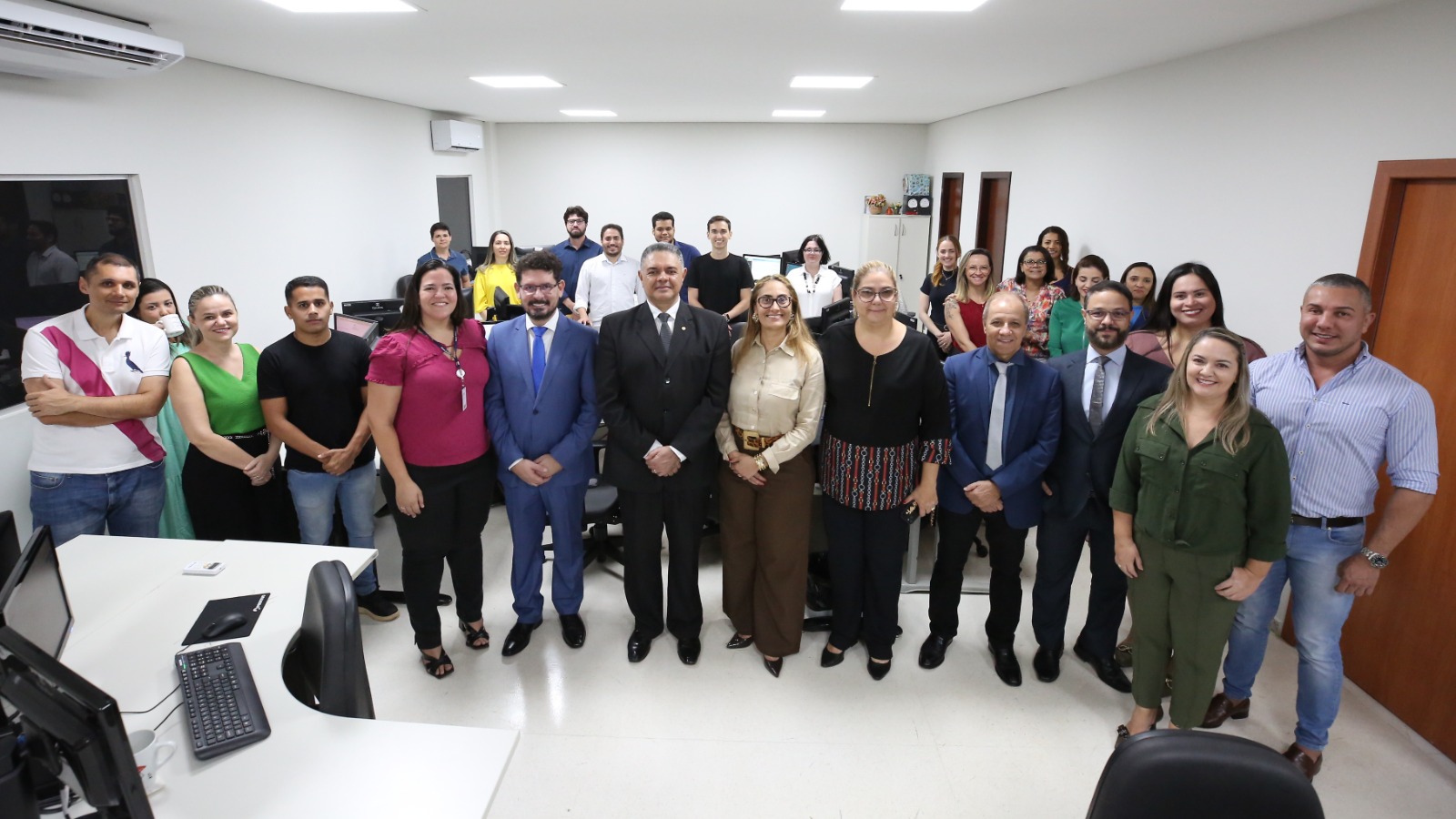 Seis magistrados sendo quatro homens e duas mulheres e vários servidores, entre pessoas do sexo masculino e feminino, em pé, de frente na sala onde vai funcionar o cartório do bloco de competência Criminal juntos
