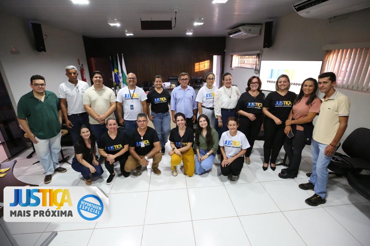 foto colorida horizontal mostra servidores e servidoras do forum do forum de itacaja e do tjto junto a presidente do tribunal no salão do juri