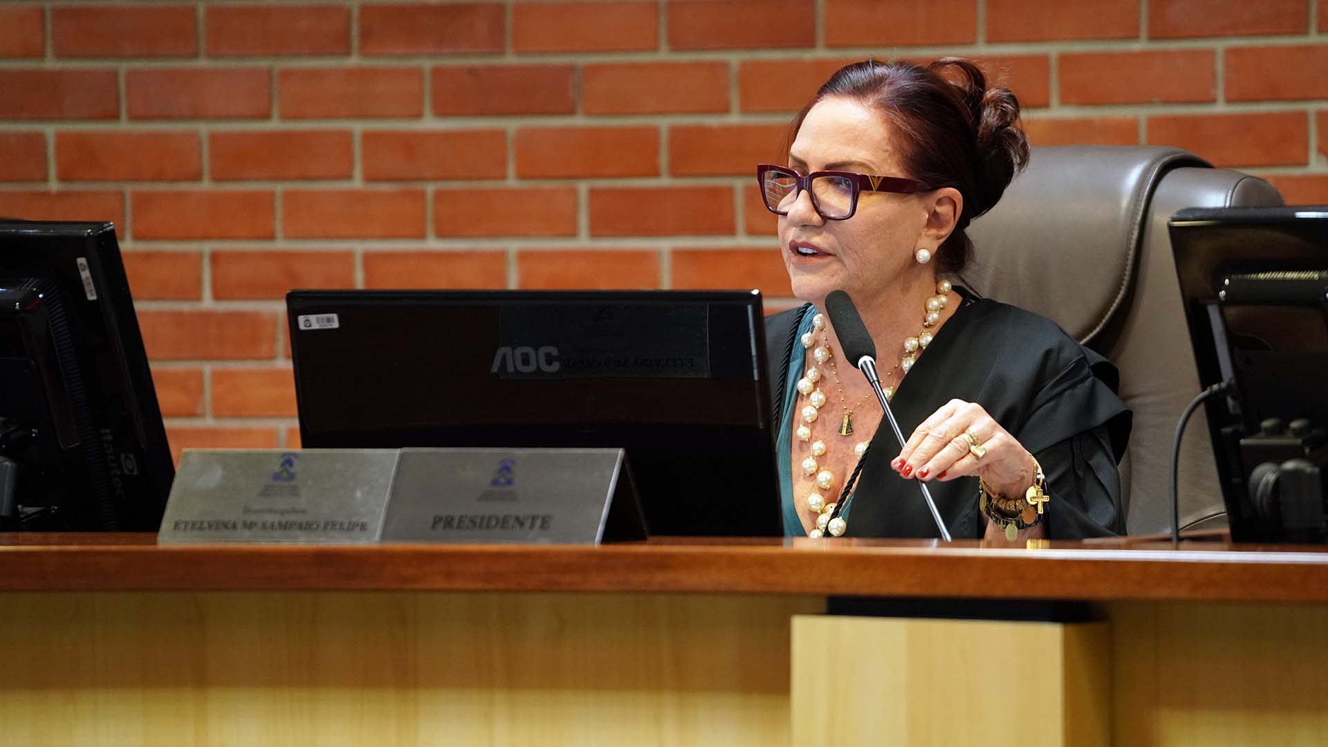 Desembargadora Etelvina conduzindo a sessão; ela fala ao microfone
