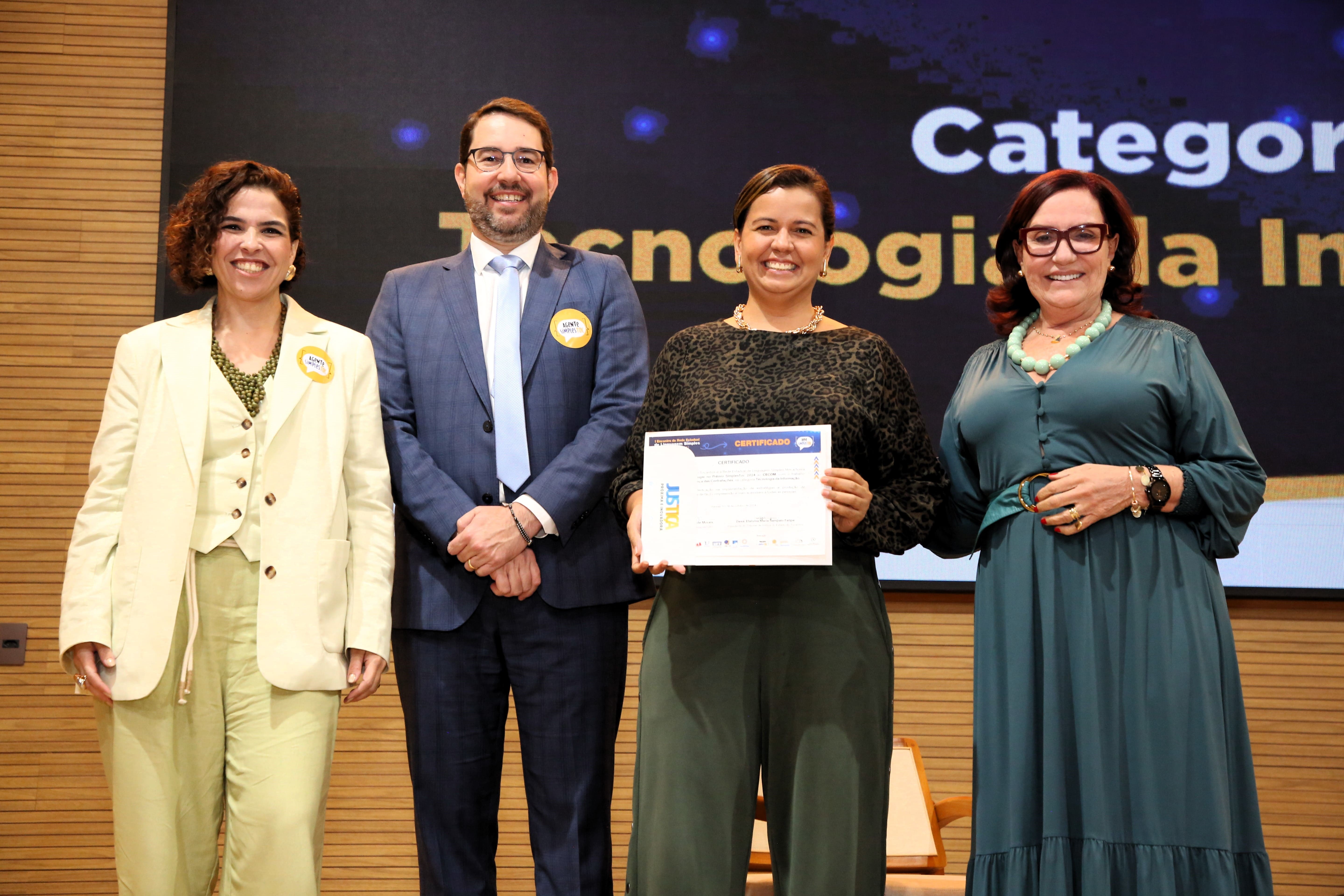 Fotografia colorida que mostra a presidente do TJTO, desa. Etelvina, entregando um certificado à Kézia Reis do Cecom, o juiz Roniclay Alves também está na foto.