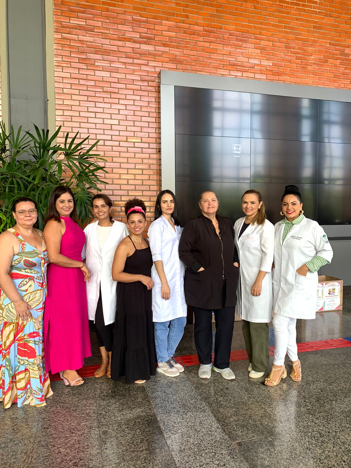 Fotografia colorida que mostra mulheres fisioterapeutas posando para a foto no hall do TJTO