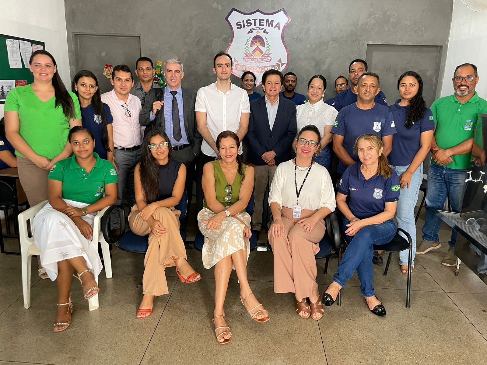 Foto da equipe que participou das audiências concentradas em Araguaína; ao centro, de blazer azul marinho, camisa branca e calça bege, o juiz Deusamar; parte do grupo está em pé e à frente aparecem cinco mulheres sentadas