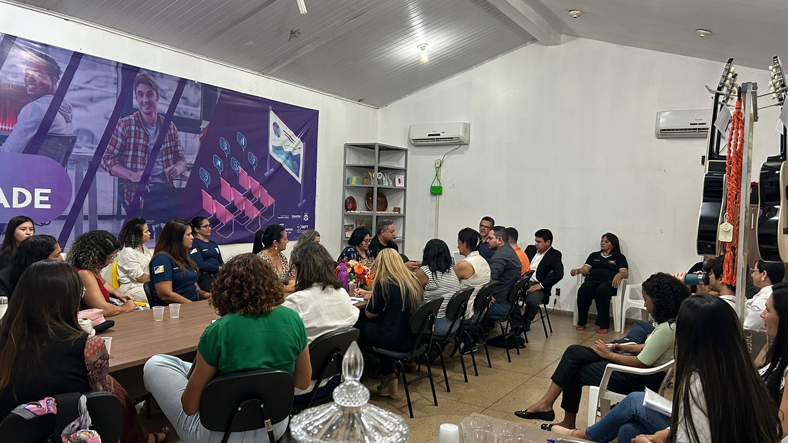 Pessoas sentadas em volta da mesa em uma sala no CASE