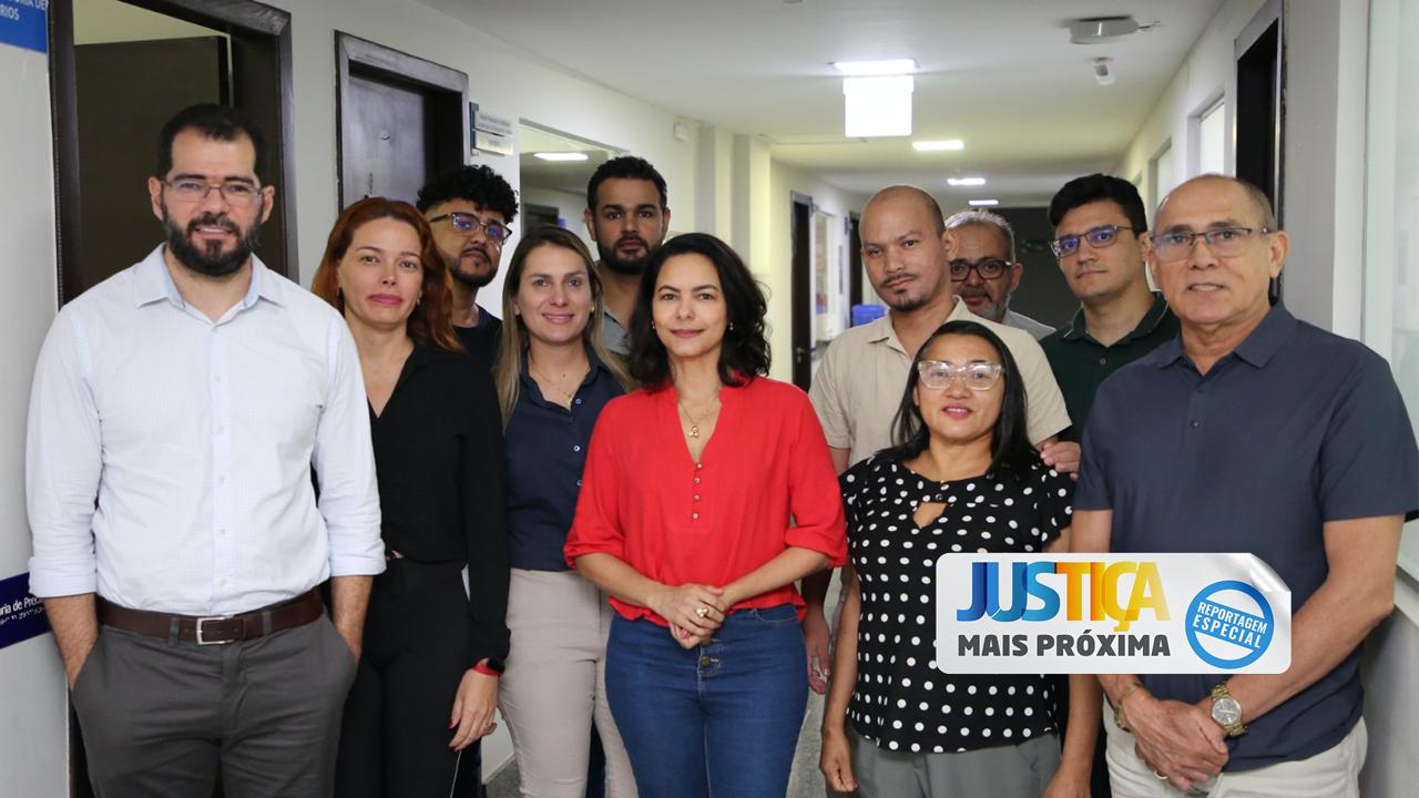 Foto da equipe da coordenadoria de Precatórios do TJ. À esquerda, o juiz Manuel de Farias ao lado de dez servidores que atuam no setor, sendo seis pessoas do sexo masculino e quatro feminino. Todos estão em pé, em um corredor em frente à sala onde funciona a coordenadoria de Precatórios  
