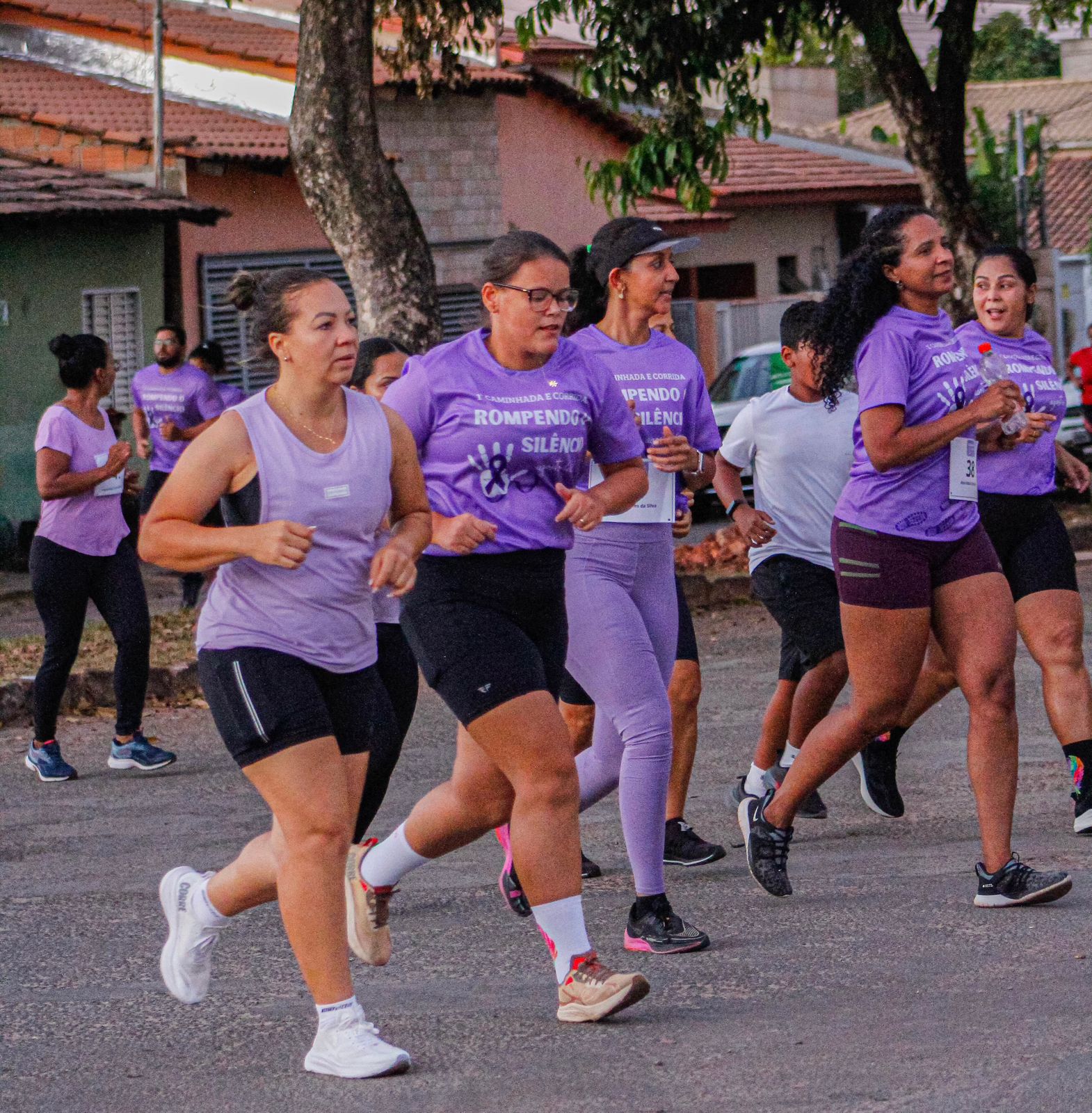 Imagem mostra um grupo de mulheres com uniformes na cor lilás participando da corrida em Dianópolis