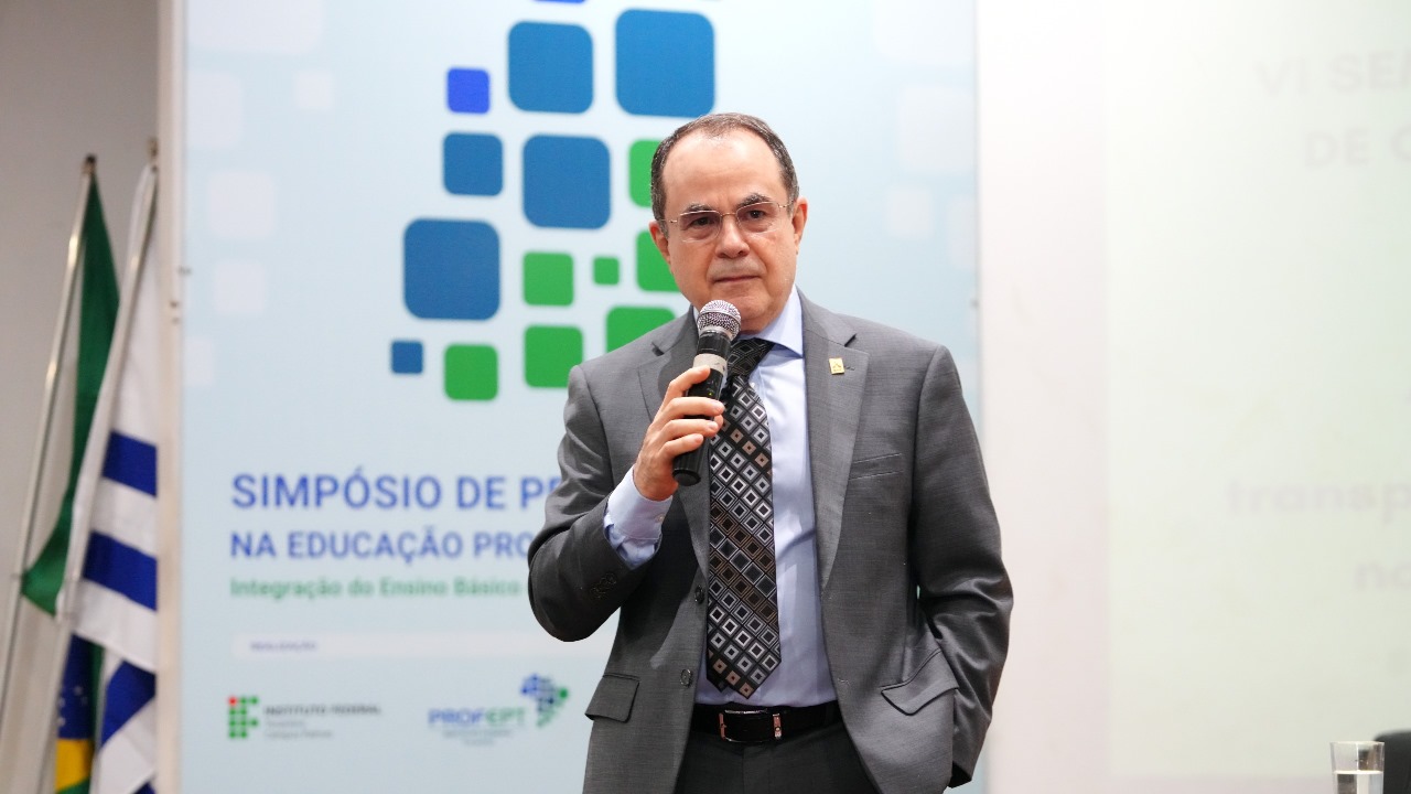 A imagem mostra o desembargador Marco Villas Boas falando ao microfone durante a conferência “Inteligência Artificial na Gestão Pública”, realizada na VI Semana Acadêmica de Gestão Pública do IFTO – Câmpus Palmas. 
