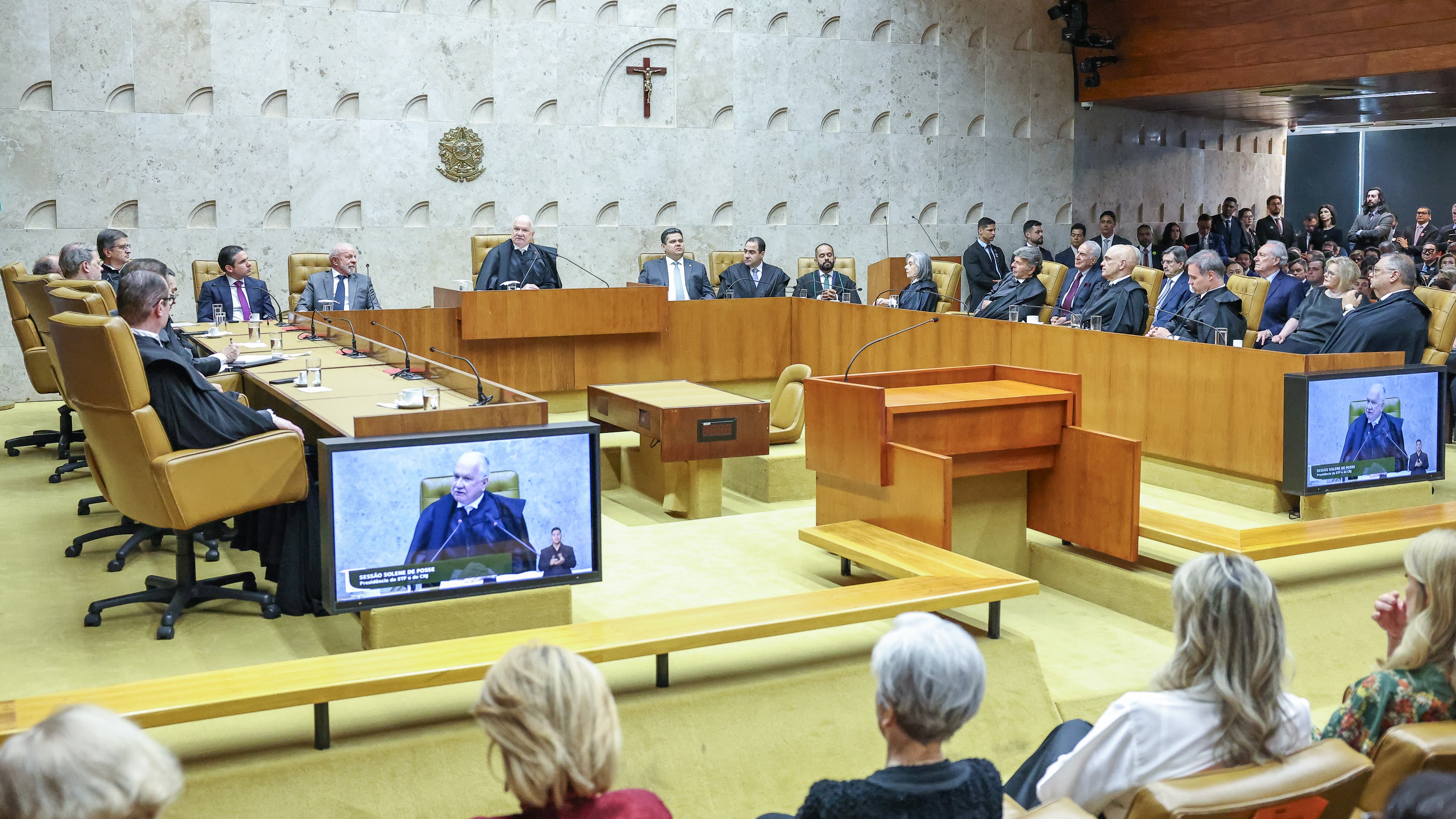 A imagem mostra Sessão solene de posse da nova presidência do STF, realizada em plenário, com ministros togados sentados à mesa, público presente e telas exibindo a transmissão ao vivo.