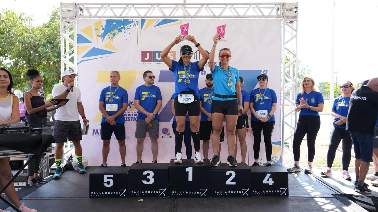 Duas servidoras no pódio com seus troféus celebram vitória