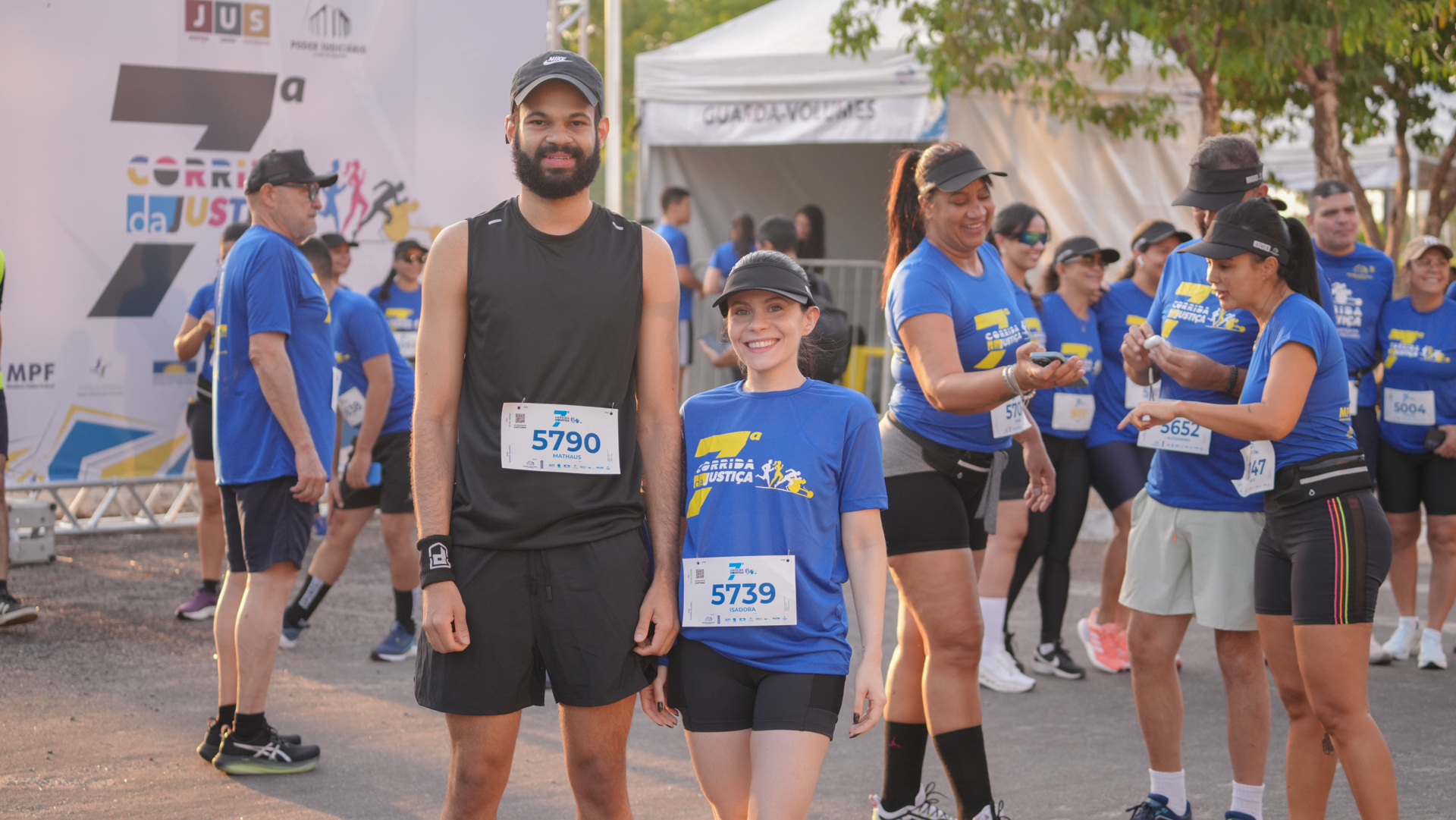 Dois servidores colegas de trabalho, ele de roupa preta e ela, à direita, de short preto e camiseta azul