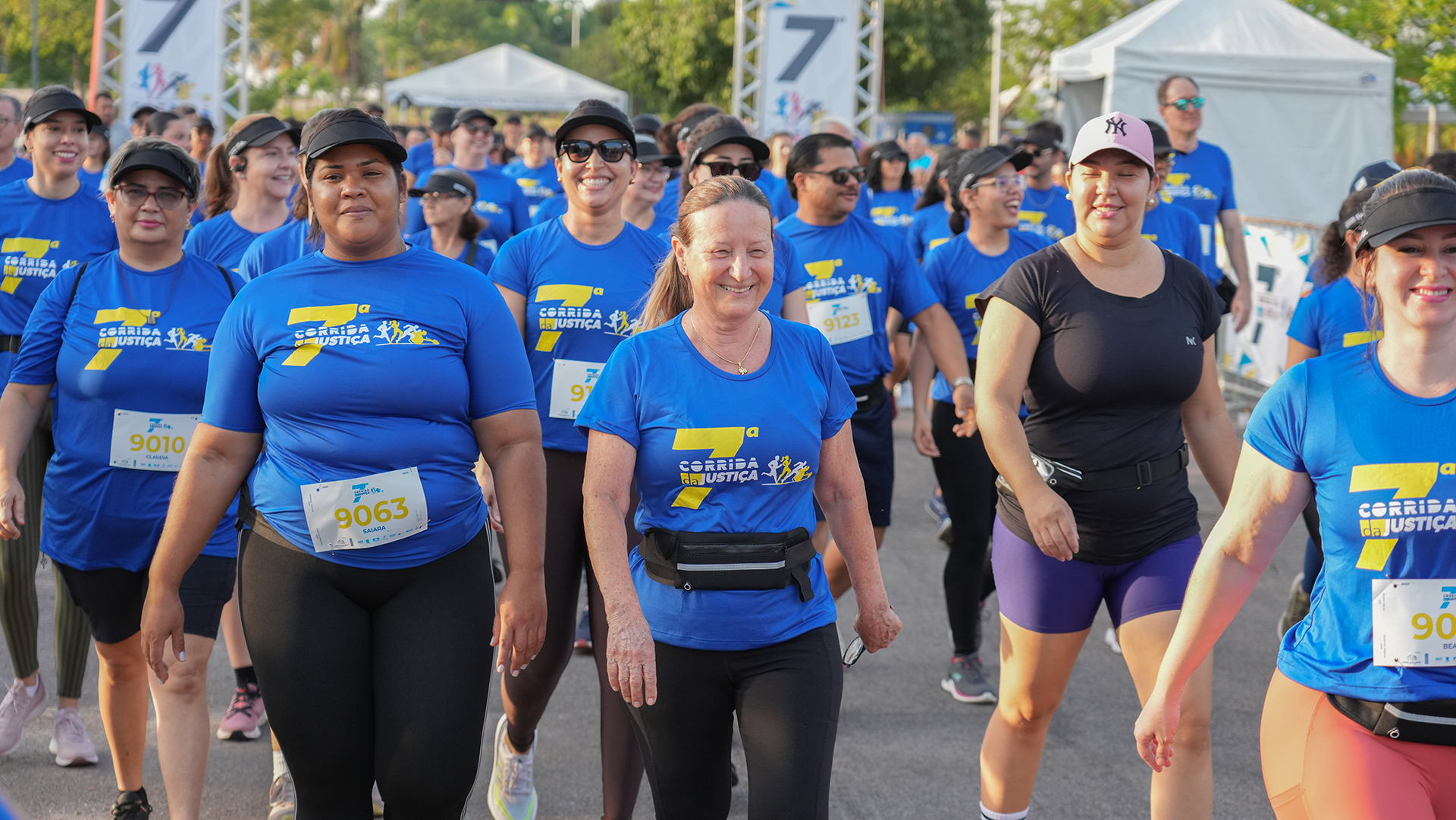 desembargadora Maysa caminha ao lado de outros participantes, todos vestidos com camiseta azul da corrida