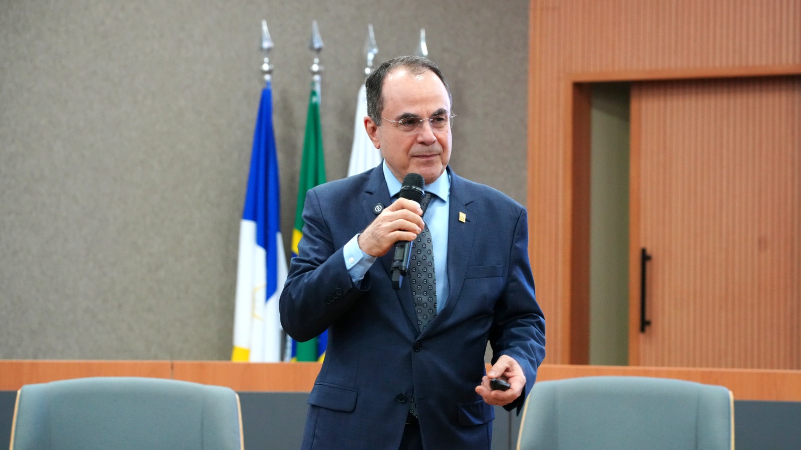 Desembargador Marco Villas Boa, de terno azul escuro e camisa azul clara, fala ao microfone durante evento