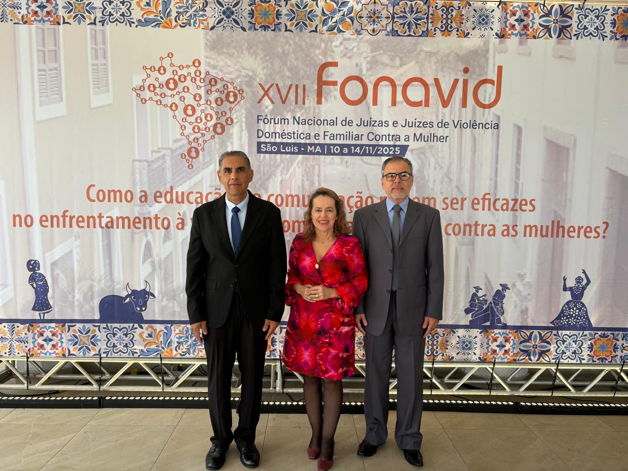 A imagem mostra três magistrados do Tribunal de Justiça do Tocantins posando para foto em frente ao painel oficial do XVII Fonavid. O fundo exibe a identidade visual do evento