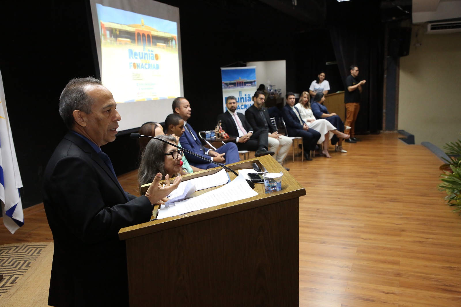 Desembargador João Rodrigues em pé no pulpito durante abertura de reunião técnica do Fonacriad no auditório do Palácio Araguaia