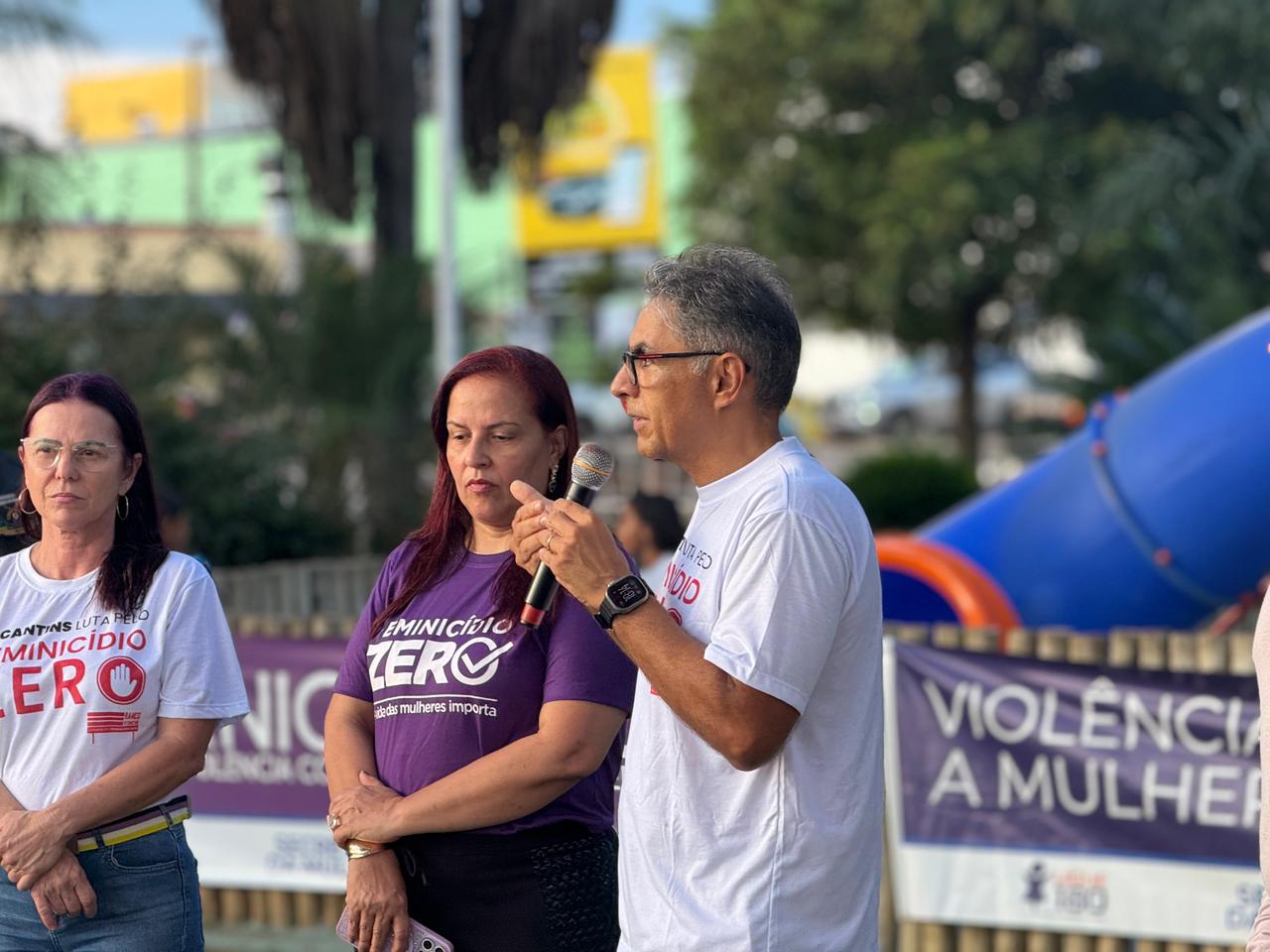 O juiz Jossanner Nery Nogueira Luna fala ao público durante o movimento “Vozes que não se calam”, realizado no Parque Mutuca, em Gurupi. Ao lado dele, participantes acompanham o pronunciamento em ato de conscientização pelo fim da violência contra a mulher e em memória das vítimas de feminicídio.