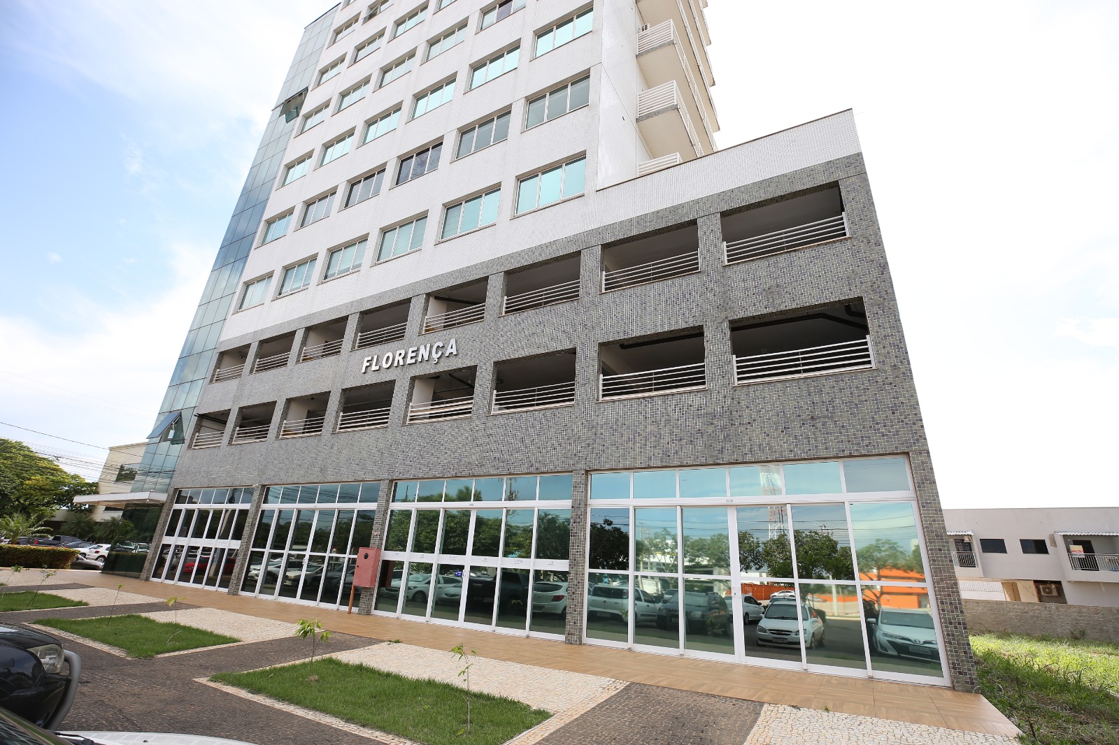 Fachada do prédio onde funciona o NAPsi, com fachada moderna em tons claros, base revestida em pastilhas cinza e identificação “FLORENÇA” em destaque.