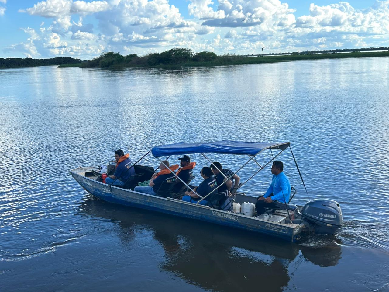 Equipe em embarcação de pequeno porte atravessa rio rumo a comunidades indígenas, com uso de coletes salva-vidas e motor de popa, evidenciando deslocamento fluvial para realização de atendimentos itinerantes.
