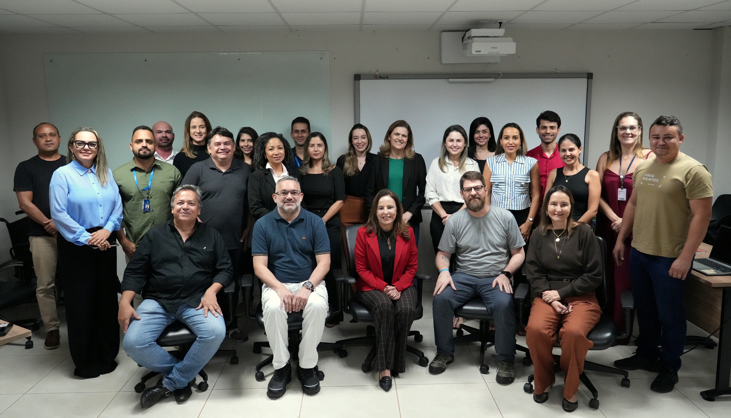 A imagem mostra um grupo de participantes reunidos em sala de aula, posando para foto, com alguns sentados à frente e outros em pé ao fundo. A cena integra o curso de elaboração do Plano de Contingência Socioambiental do Poder Judiciário do Tocantins, evidenciando a participação coletiva na capacitação.