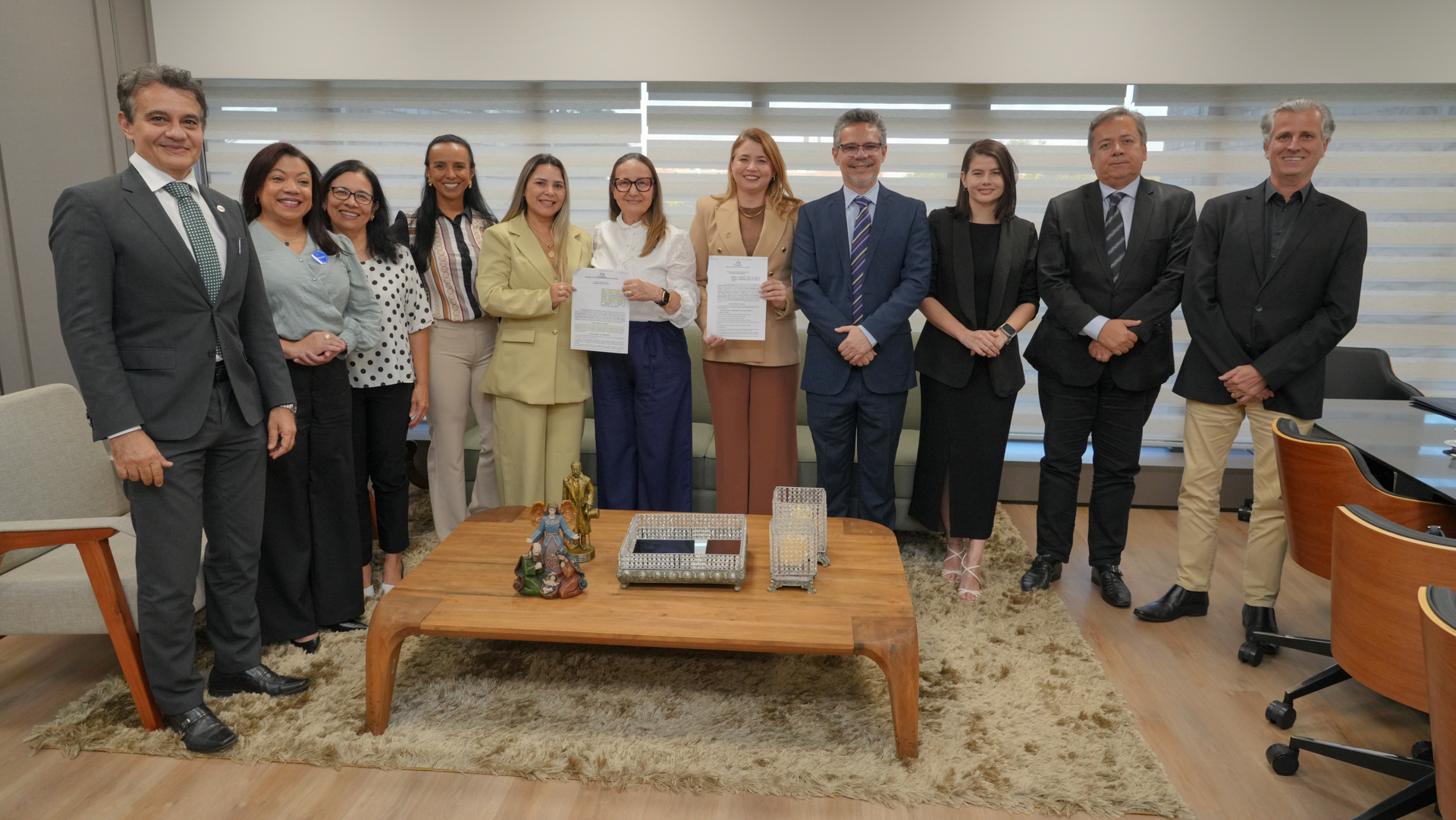 A presidente do Tribunal de Justiça do Tocantins, desembargadora Maysa Vendramini Rosal, e a vice-reitora da Universidade Estadual do Tocantins (Unitins), Darlene Teixeira, posam ao centro ao lado de magistrados, servidoras da Coordenadoria da Infância e Juventude e representantes de instituições parceiras após a formalização da adesão da Unitins ao Programa Novos Caminhos.