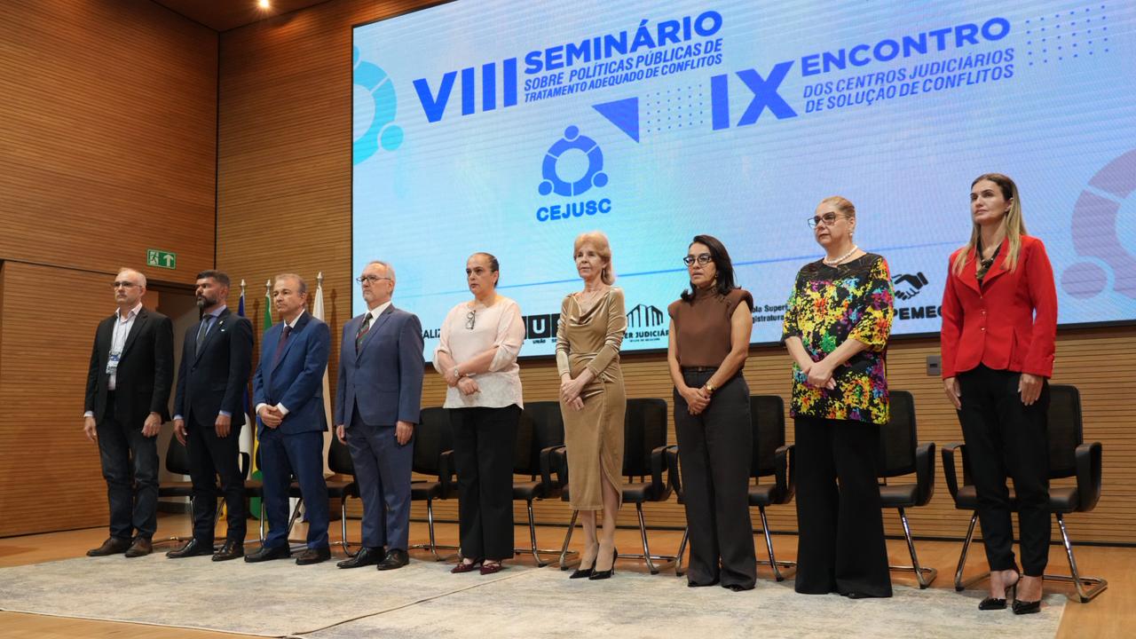 Autoridades participantes da abertura do VIII Seminário sobre Políticas Públicas de Tratamento Adequado de Conflitos e IX Encontro dos Cejuscs posam no palco do auditório do TJTO durante a solenidade realizada em Palmas.