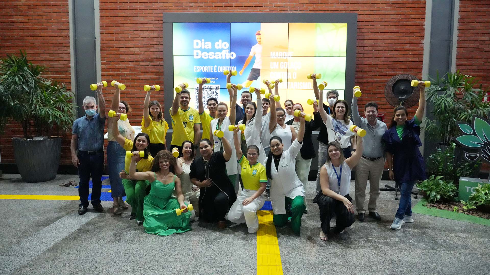 A imagem mostra magistrados, servidores e colaboradores do TJTO reunidos durante o Dia do Desafio 2026, segurando pesos e posando de forma animada após a atividade física.