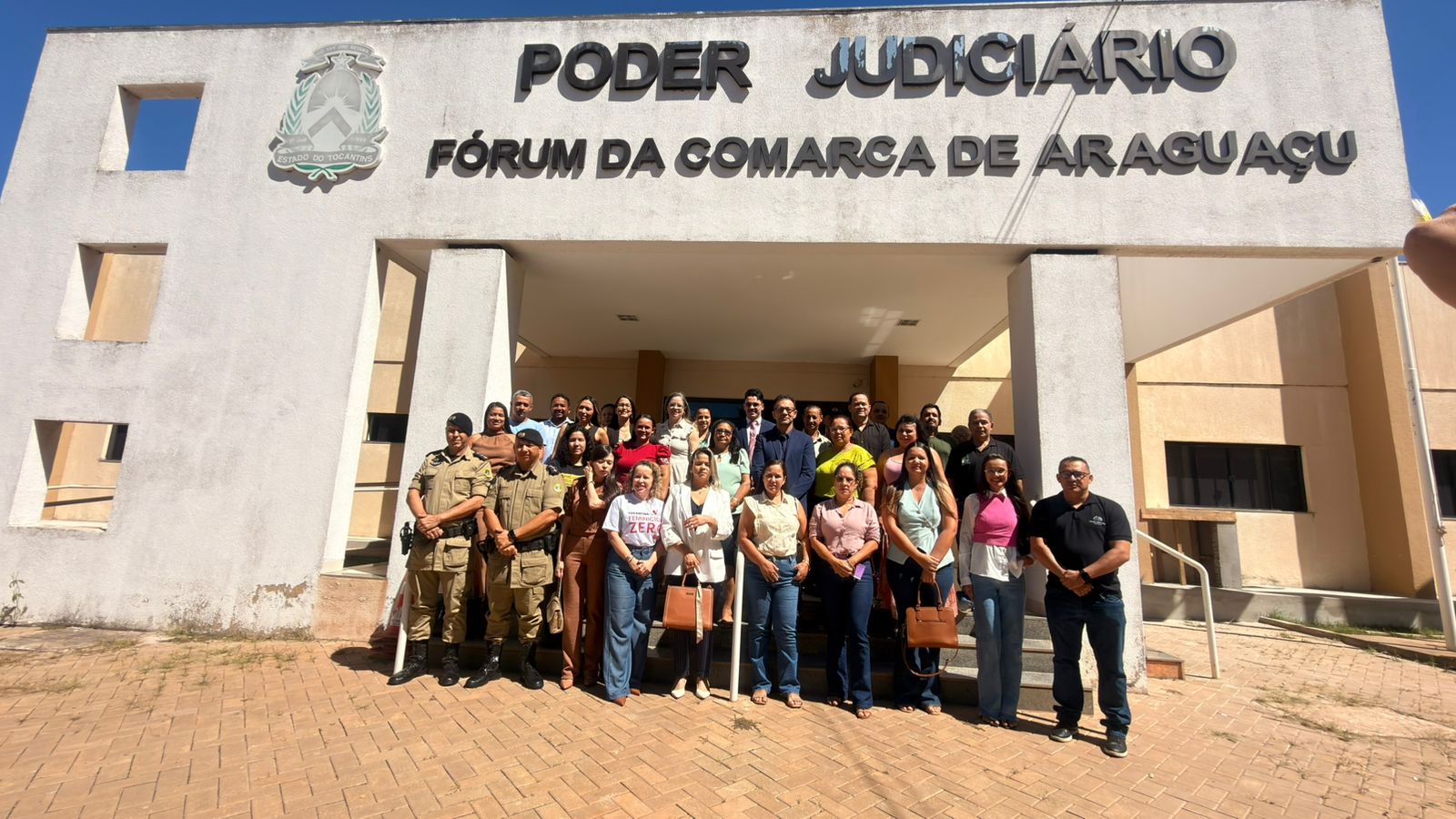A juíza Cirlene Maria de Assis, representantes da rede de proteção à mulher, integrantes do Poder Judiciário, forças de segurança e instituições parceiras posam em frente ao Fórum da Comarca de Araguaçu durante agenda institucional voltada ao fortalecimento das ações de enfrentamento à violência doméstica e familiar.