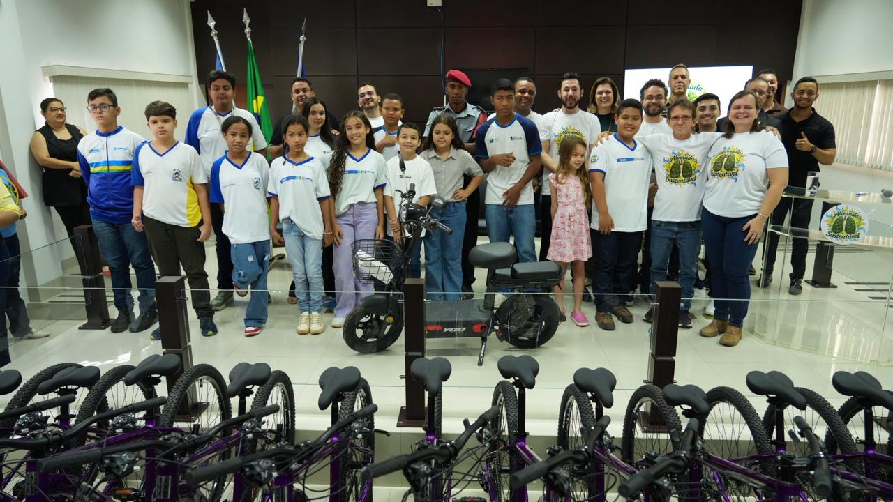 A imagem mostra os estudantes premiados na quarta edição do Projeto Alvorada Sustentável reunidos ao lado das bicicletas e da bicicleta elétrica entregues durante a cerimônia de encerramento.