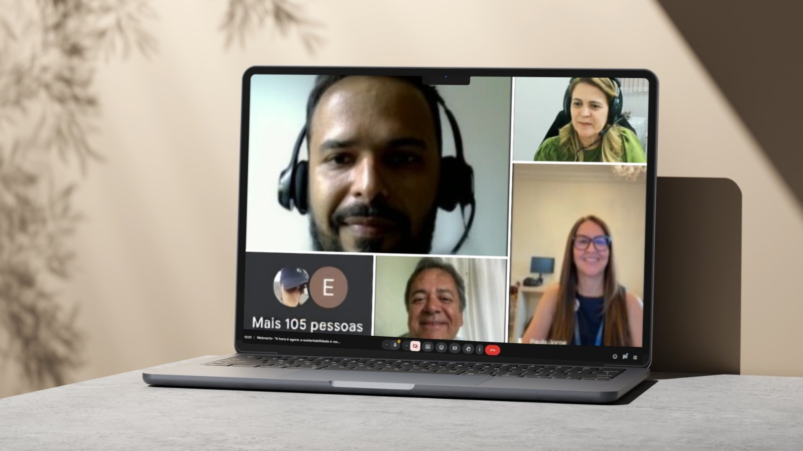 A imagem mostra um notebook sobre uma mesa. Na tela, aparecem vários participantes com câmera ligada, usando fones de ouvido, além da indicação de mais de 100 pessoas acompanhando o Webinário – A hora é agora: A sustentabilidade é responsabilidade de quem.