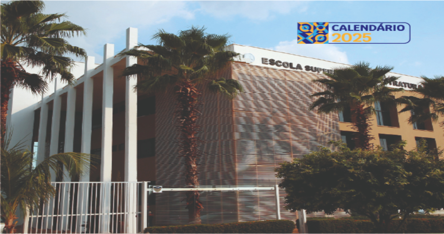 Imagem de detalhe da fachada do prédio da Esmat; estrutura moderna com paredes pintadas nas cores branca e marrom, vidraças escuras, muro e portão em grades de ferro na cor branca; à frente árvore e palmeiras 