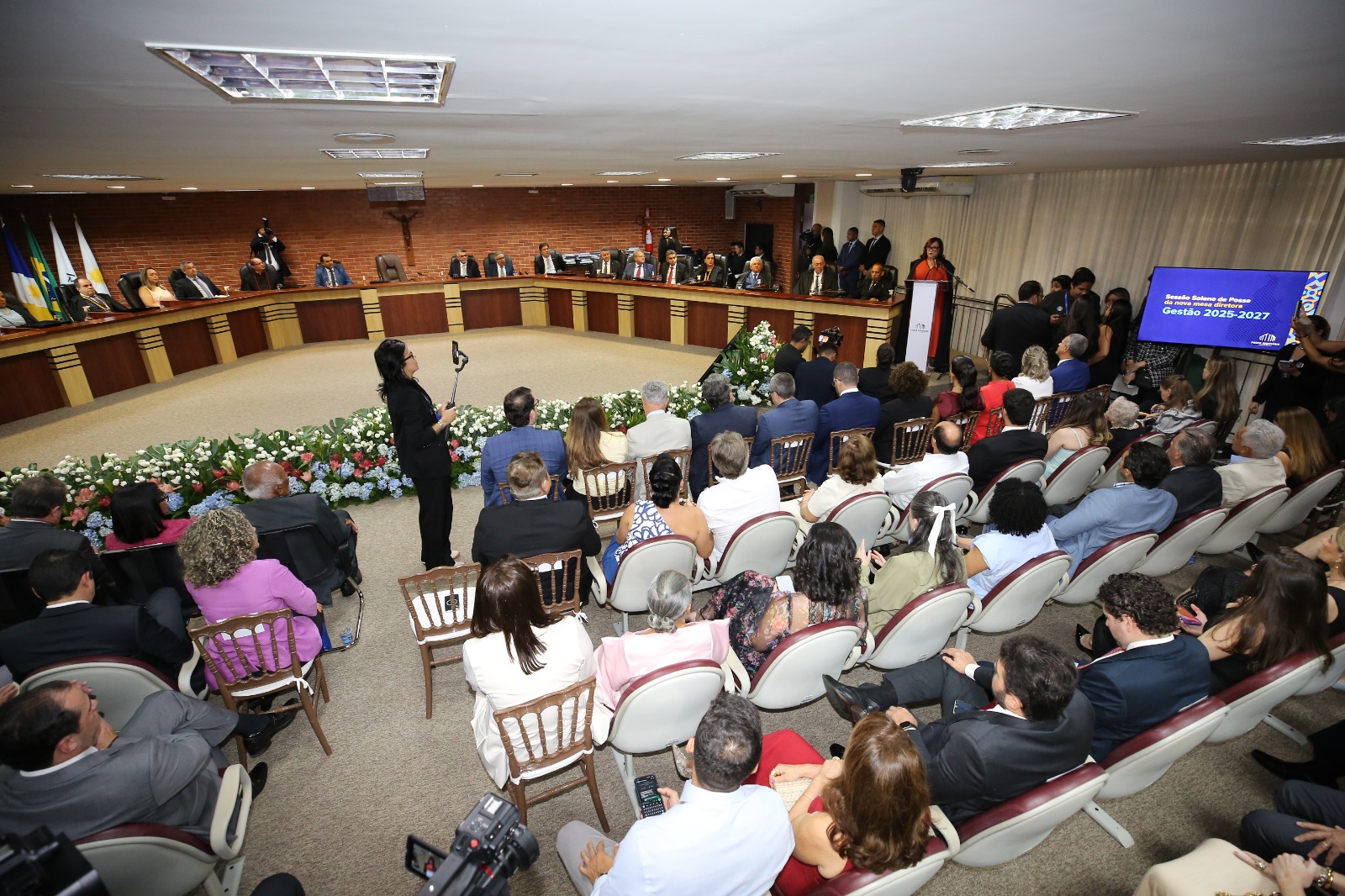 Fotografia aberta do Pleno do TJTO; ao fundo desembargadores e autoridades sentados e a desembargadora Etelvina à direita, falando ao microfone