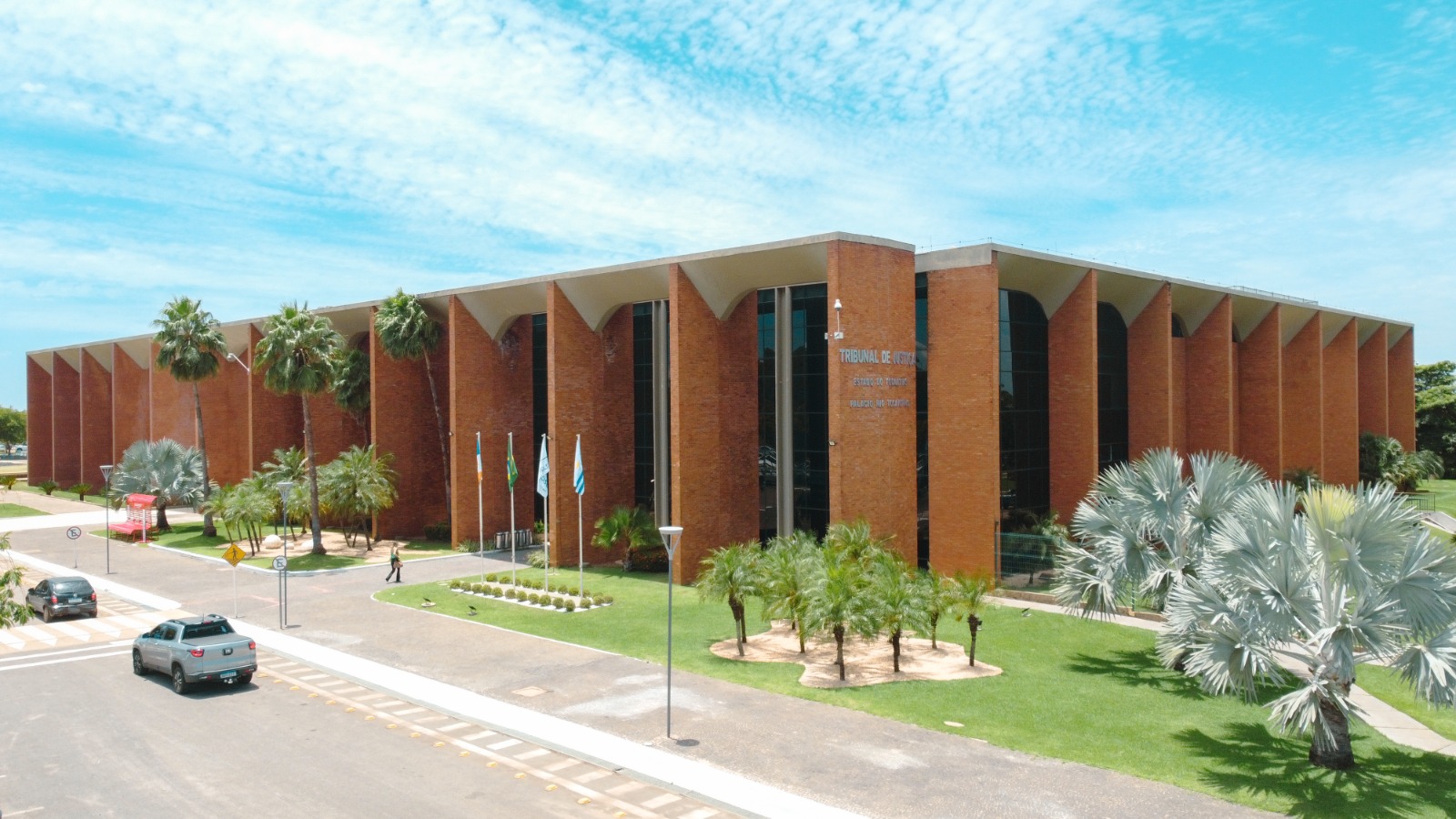 Fachada lateral do prédio do Tribunal de Justiça do Tocantins em tijolinho exposto em colunas e peles de vidro escuro