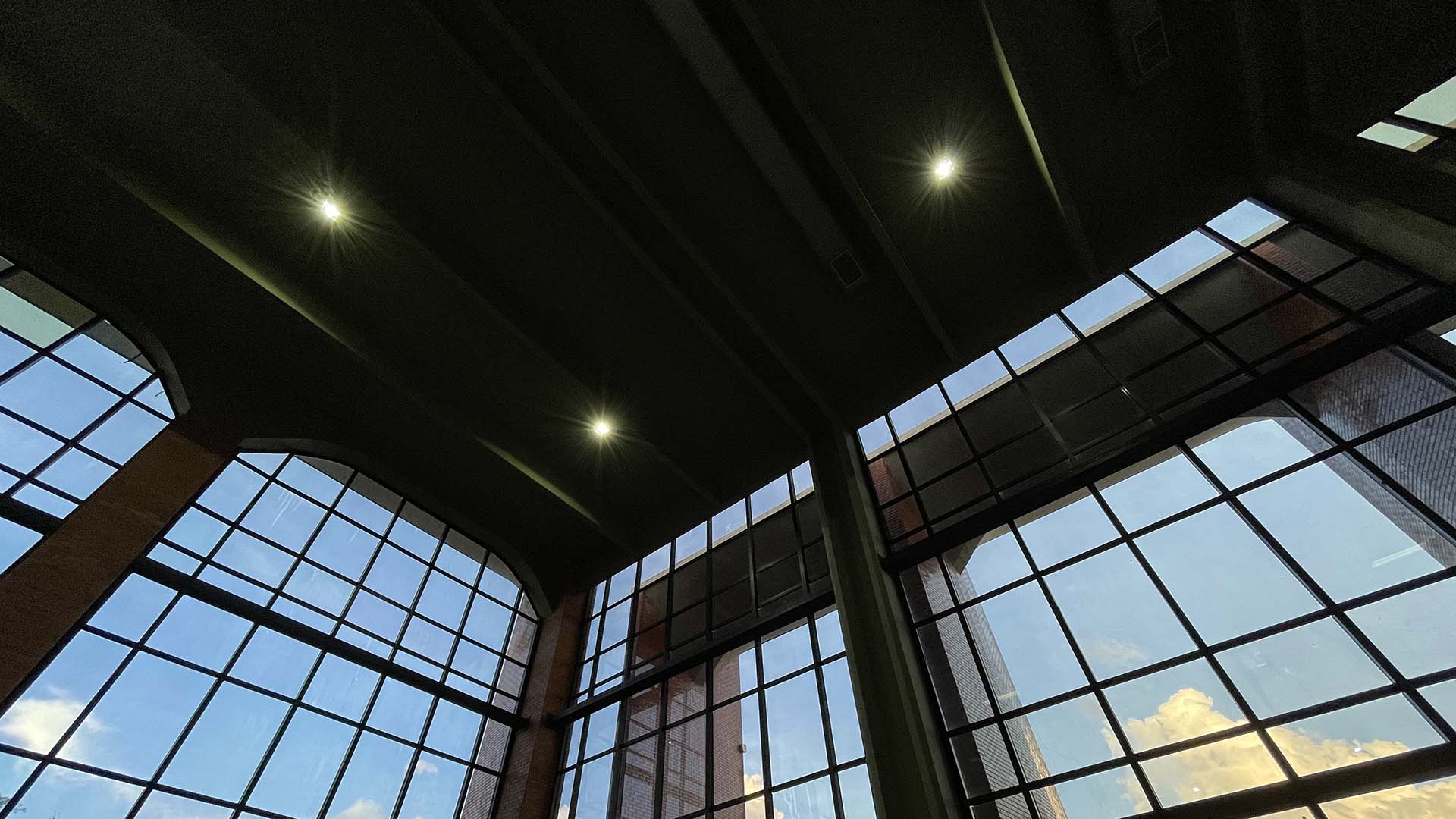 Imagem interna do prédio do TJTO, mostrando película de vidro e parte do teto com iluminação com spots