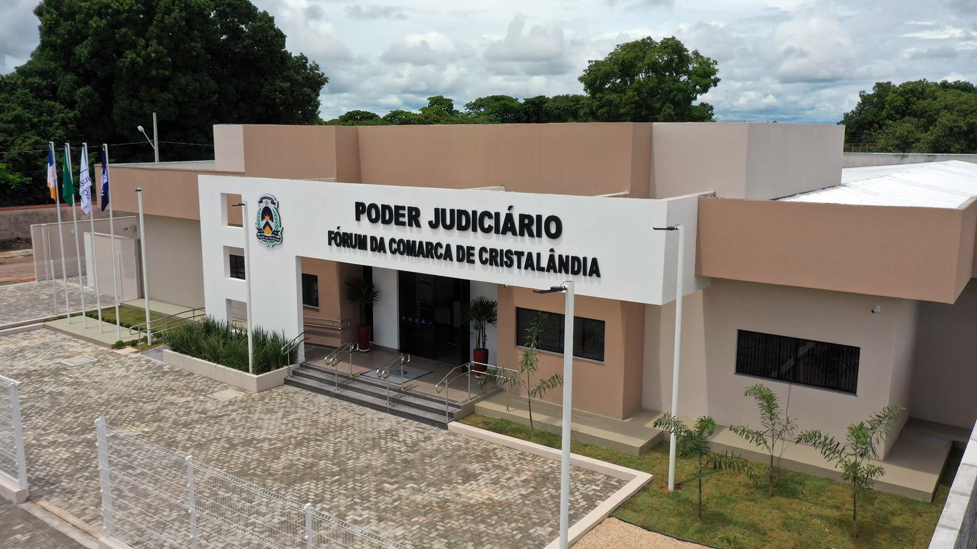 Fachada do prédio do Fórum da Comarca de Cristalândia, com estrutura pintada nas cores marrom, bege e branco; à frente a identificação com o nome Poder Judiciário Fórum da Comarca de Cristalândia